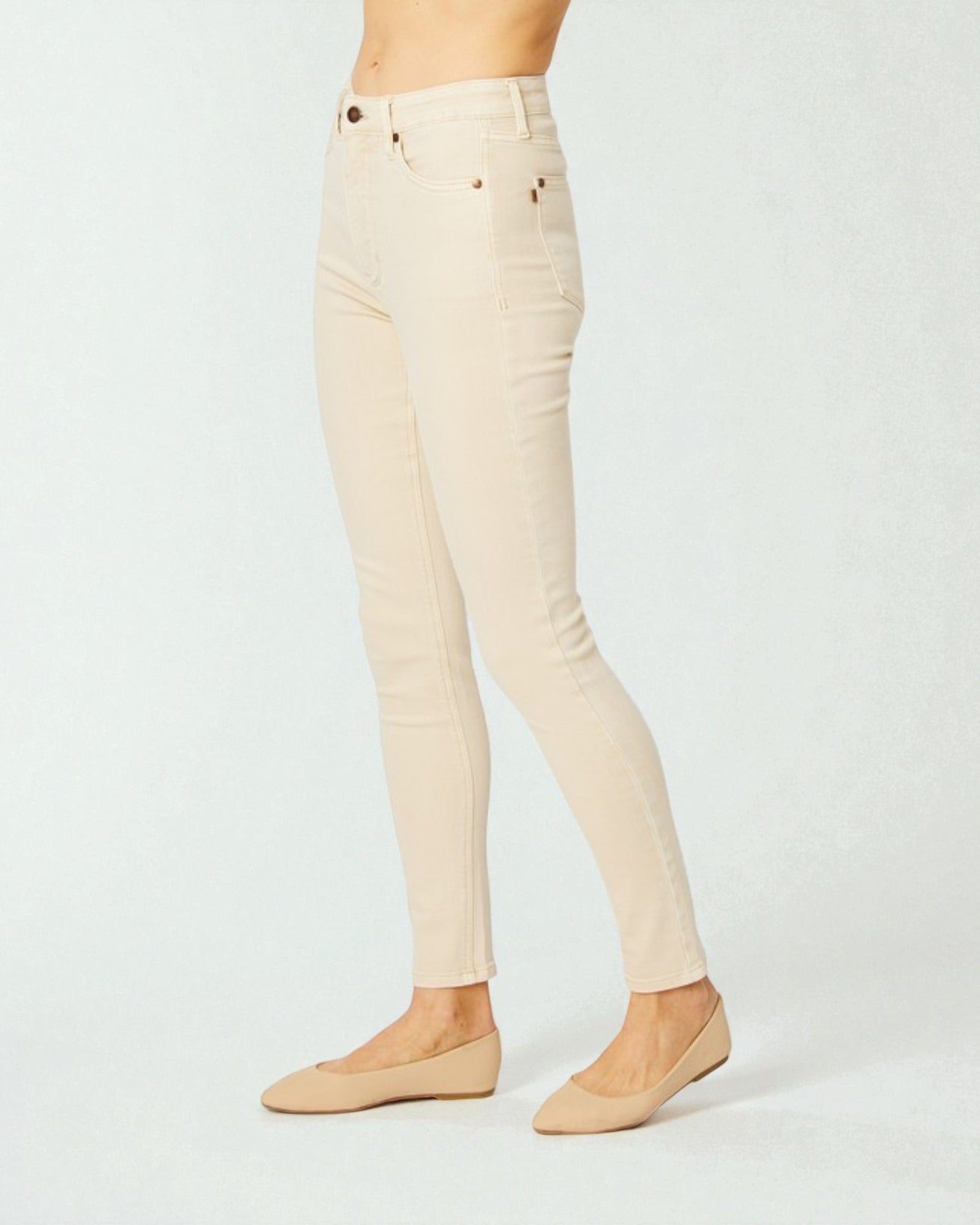 Beige pants worn by a person on a white background