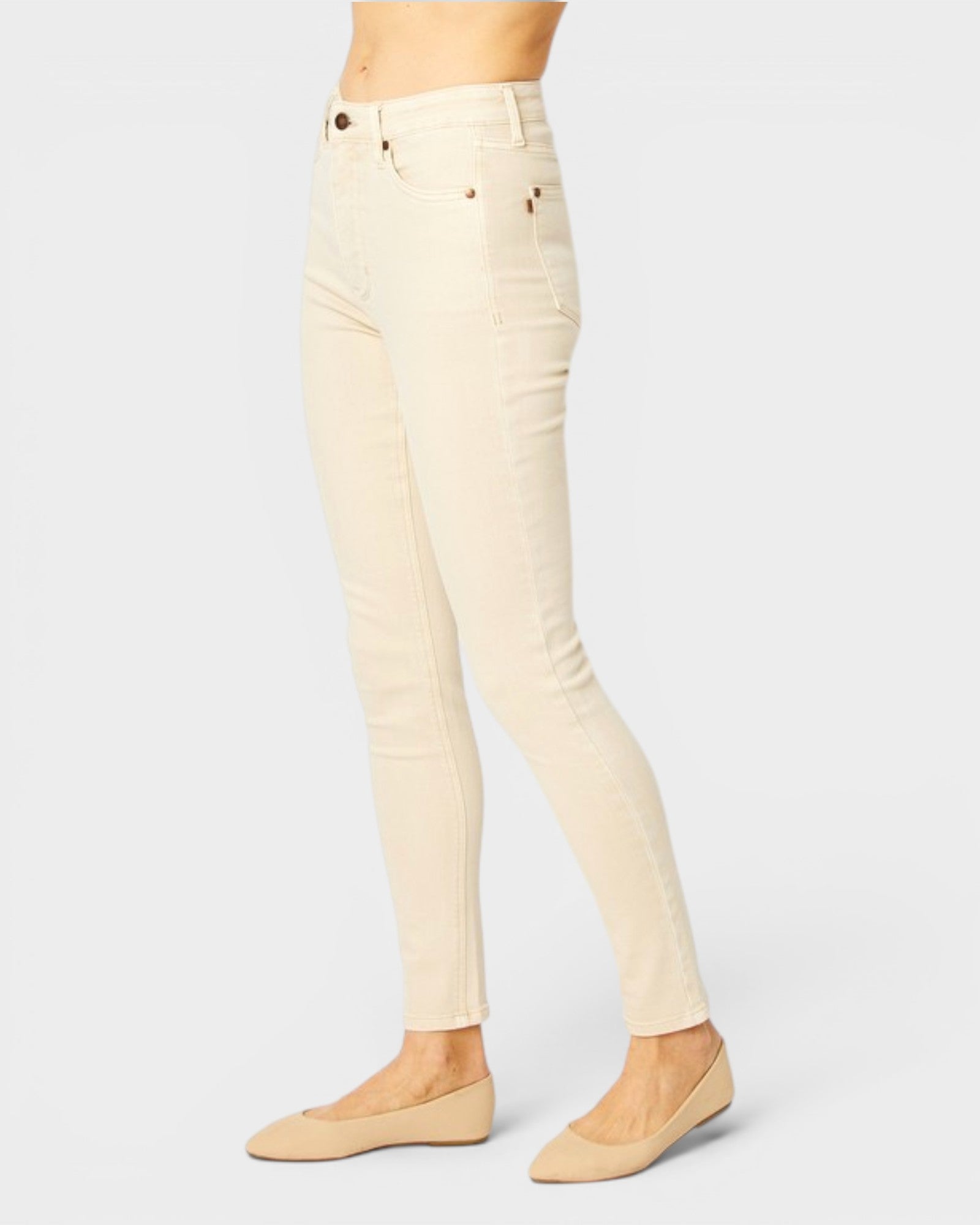 Beige jeans worn by a person on a light gray background