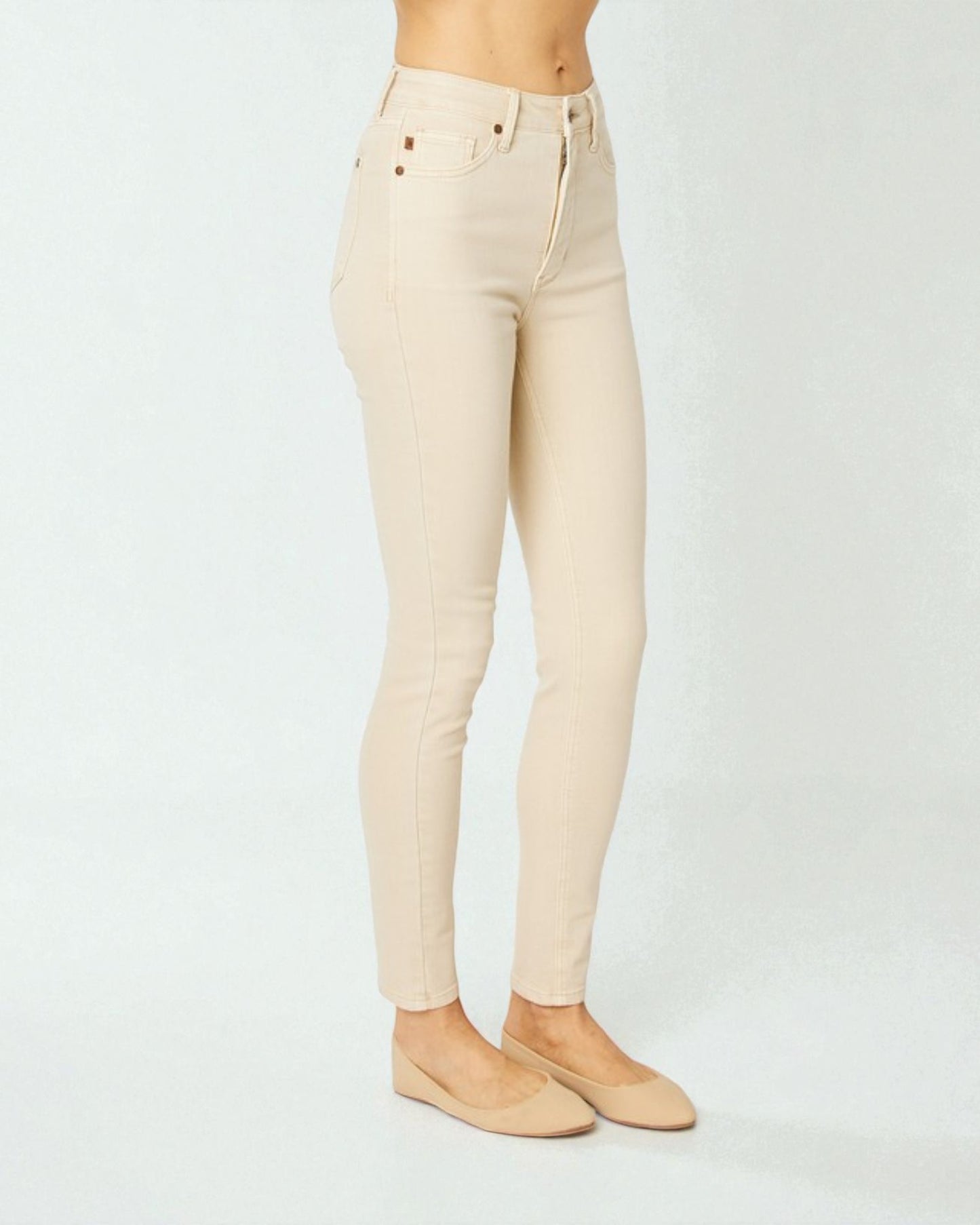 Beige jeans worn by a person on a white background