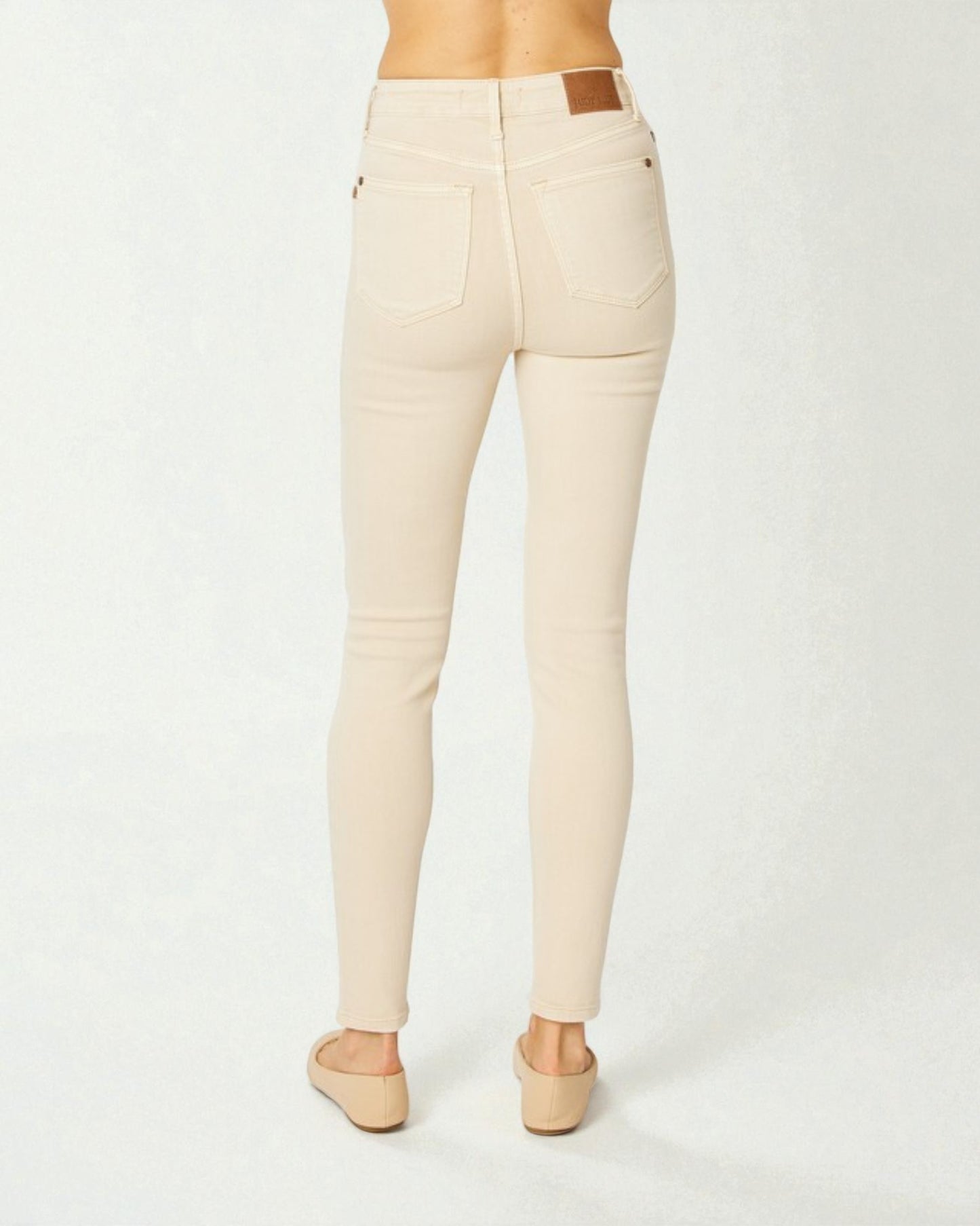 Beige pants worn by a person on a white background