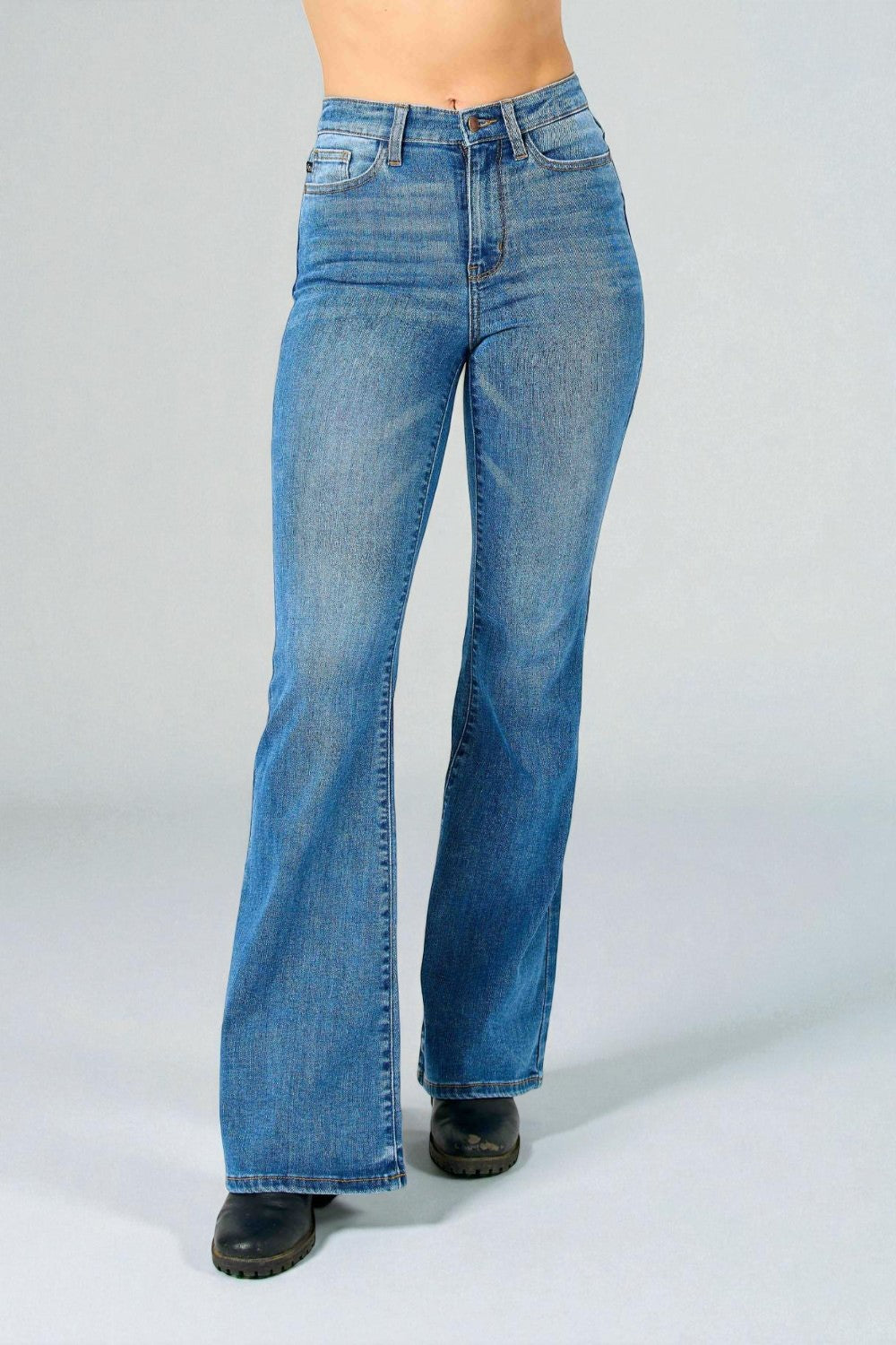 Blue jeans worn by a person on a plain background
