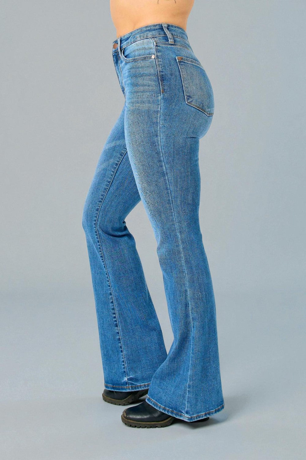 Blue jeans worn by a person on a gray background