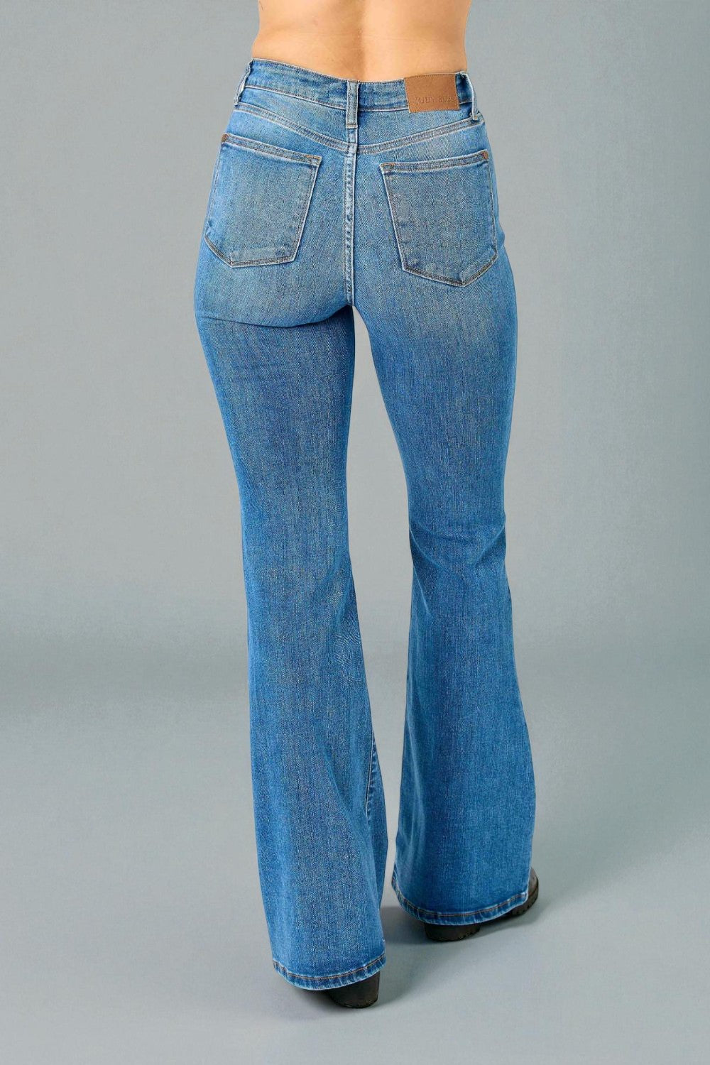 Blue bell-bottom jeans on a gray background