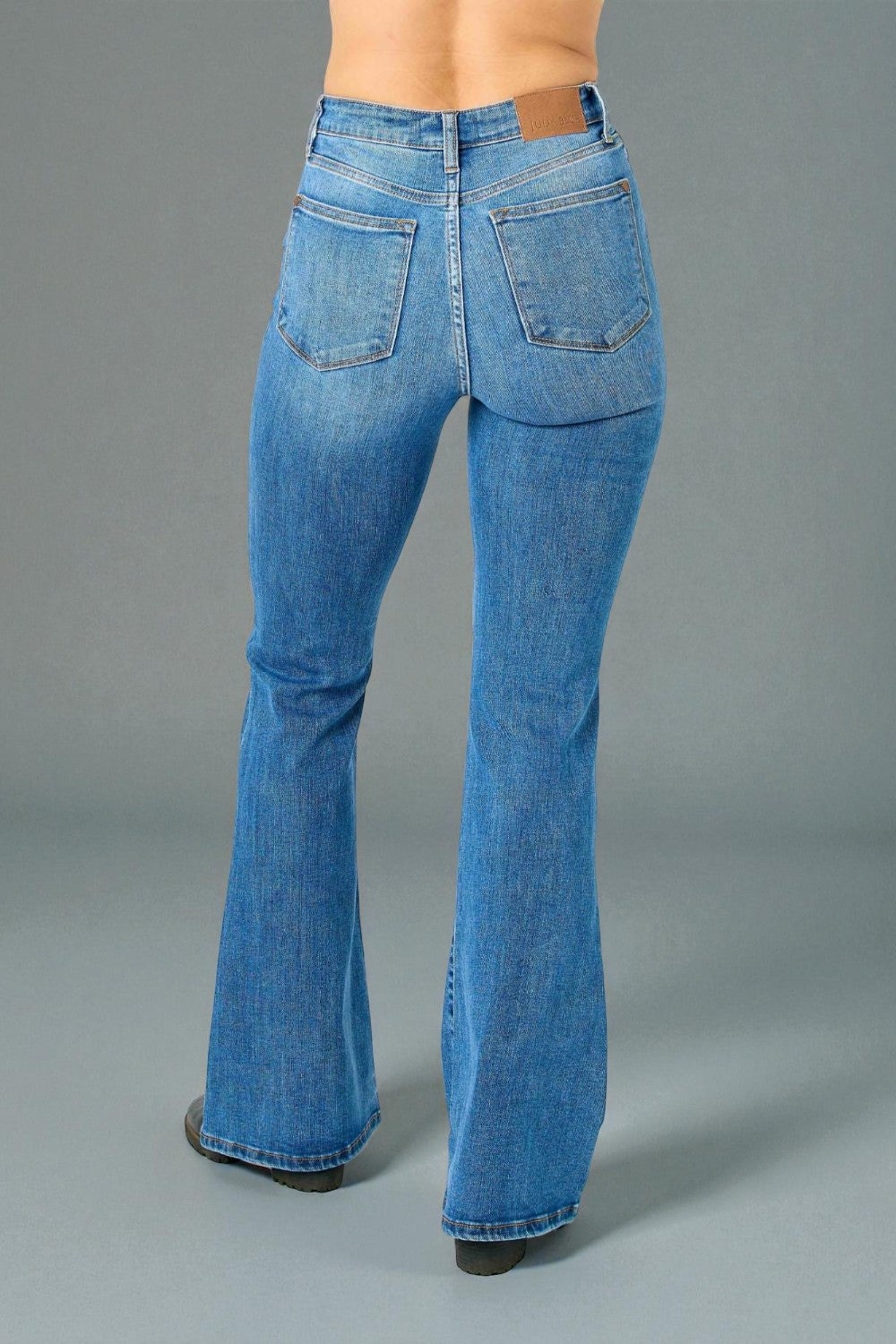 Blue bell-bottom jeans on a gray background