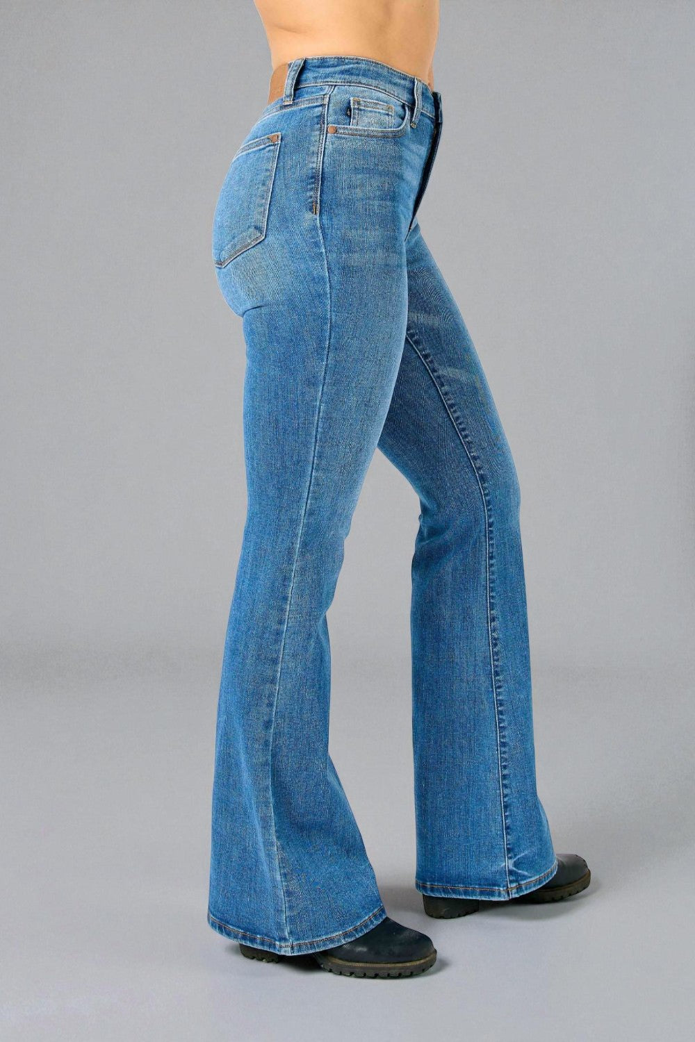 Blue bell-bottom jeans on a gray background