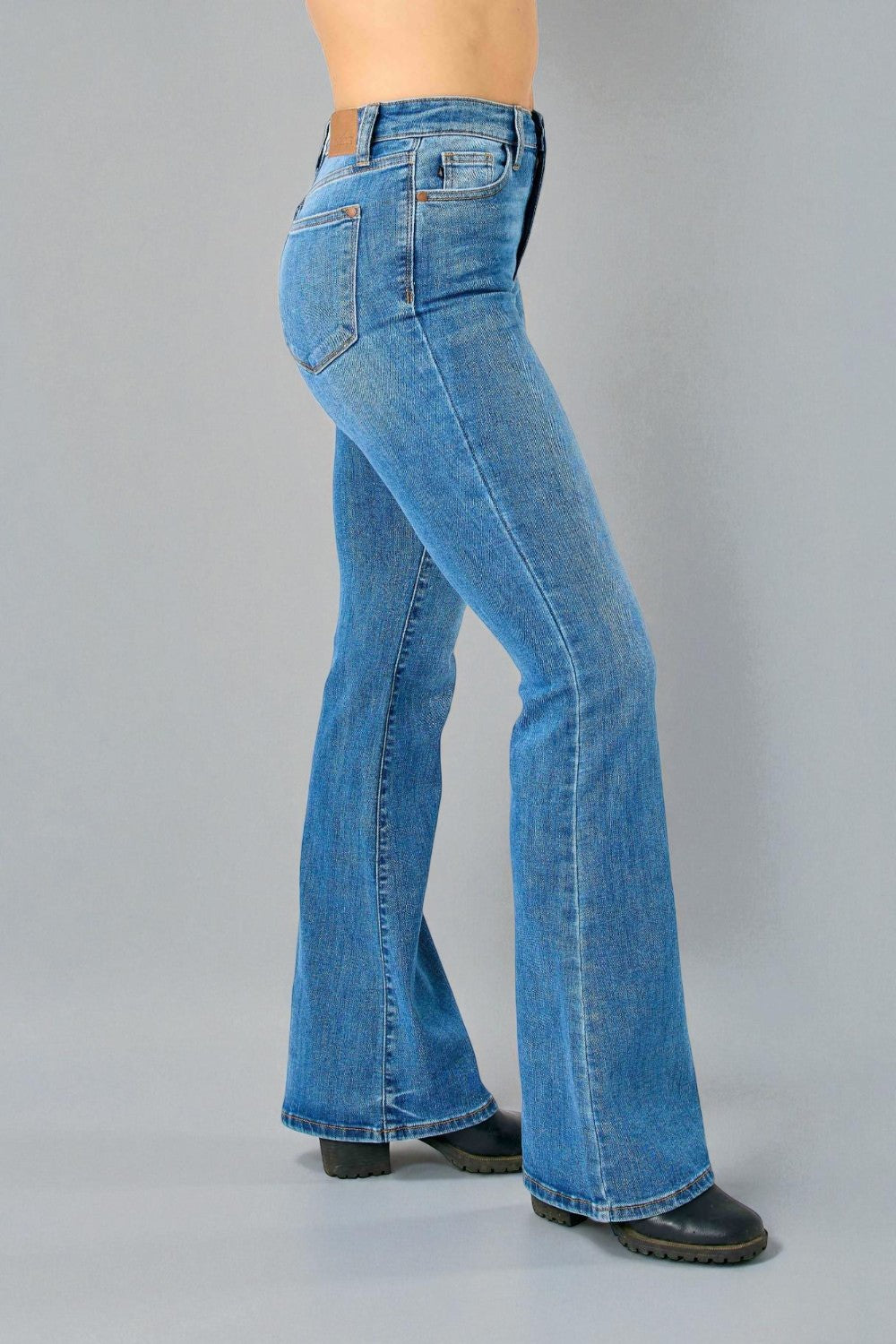 Blue jeans worn by a person on a gray background