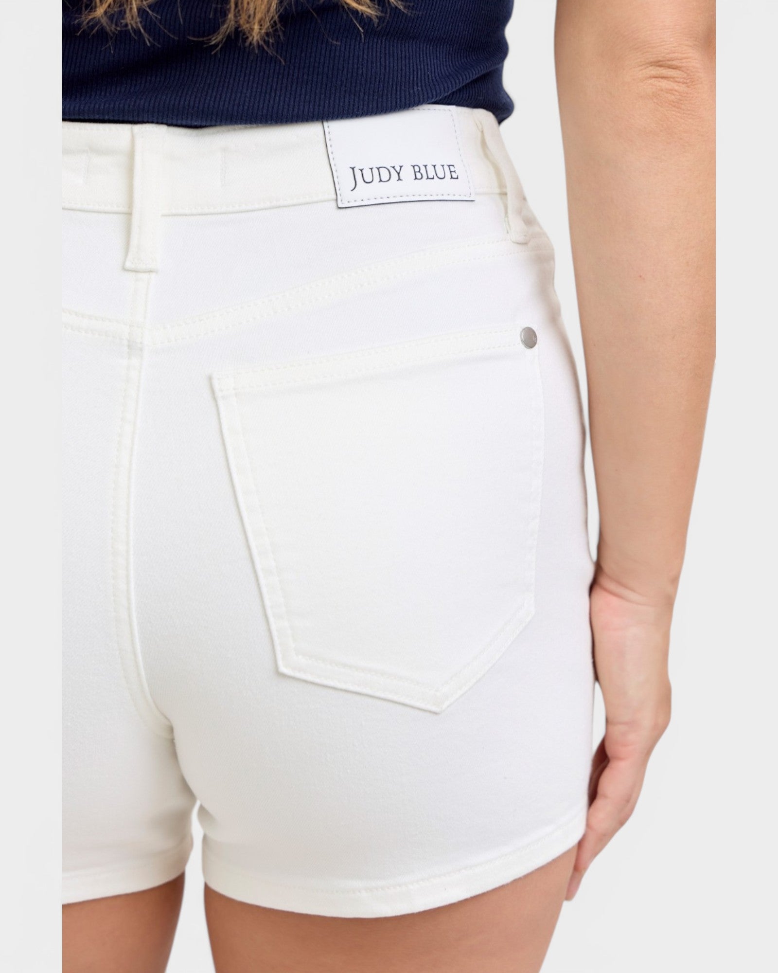 White shorts with 'Judy Blue' label worn by a person on a white background