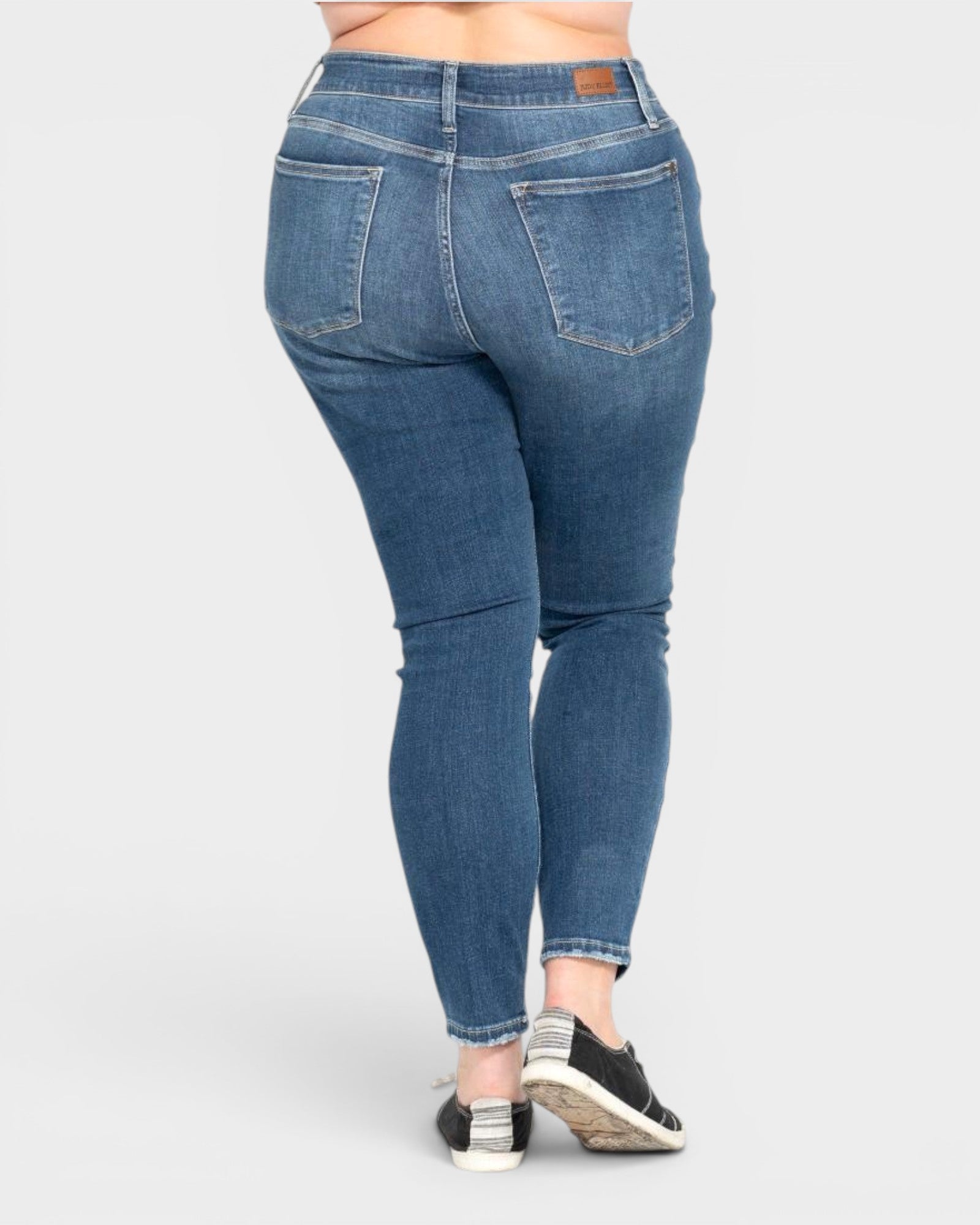 Blue jeans worn by a person on a white background