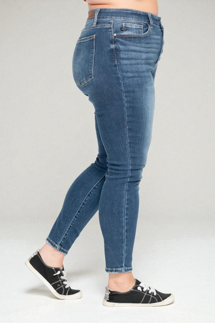 Person wearing blue jeans on a plain background