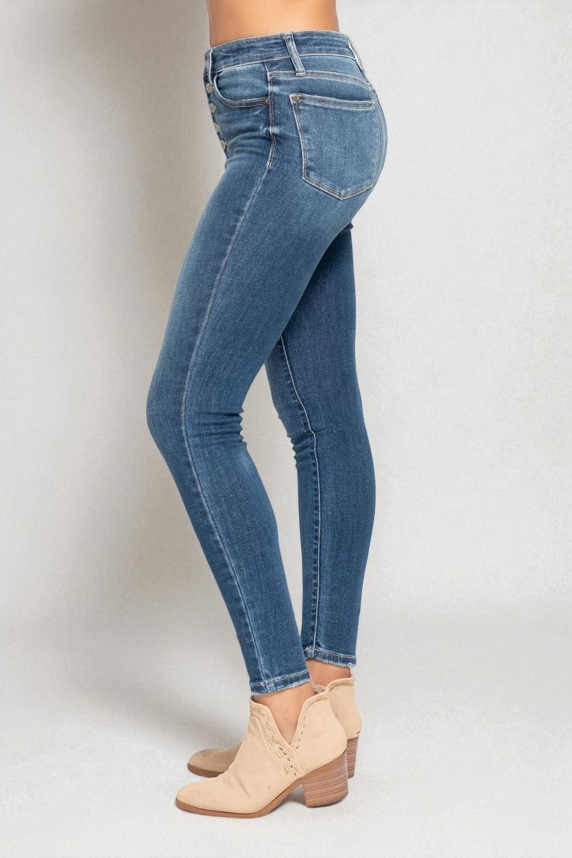 Blue jeans worn by a person on a plain background