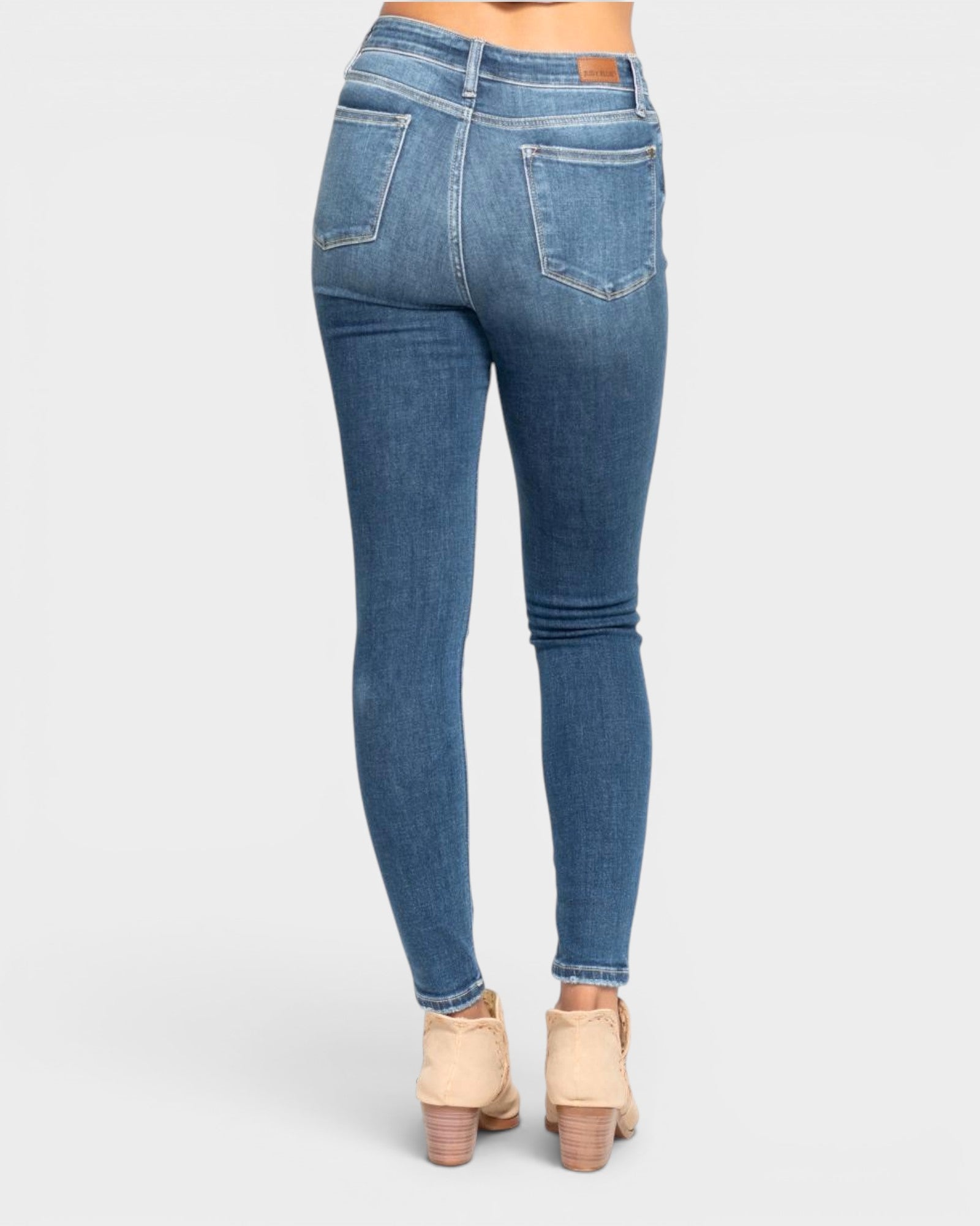 Blue jeans worn by a person on a white background