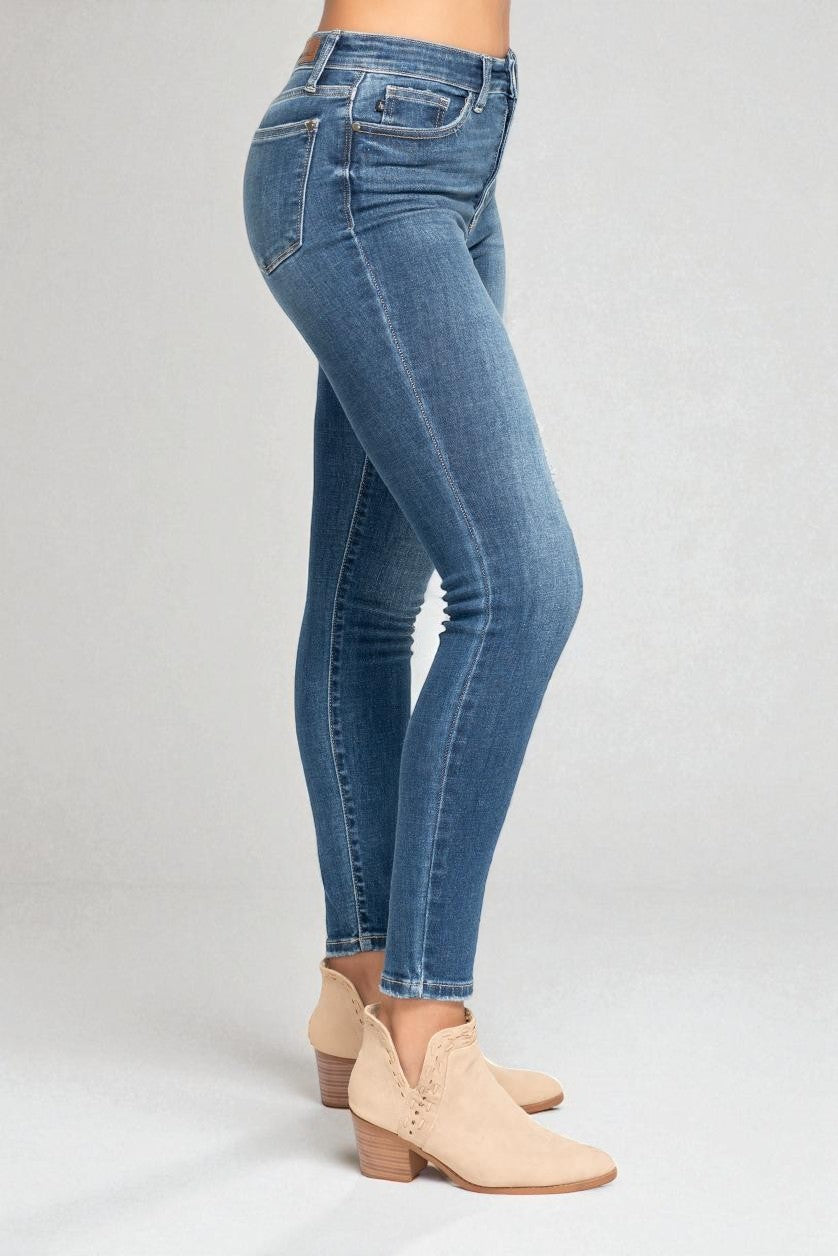 Blue jeans worn by a person on a gray background