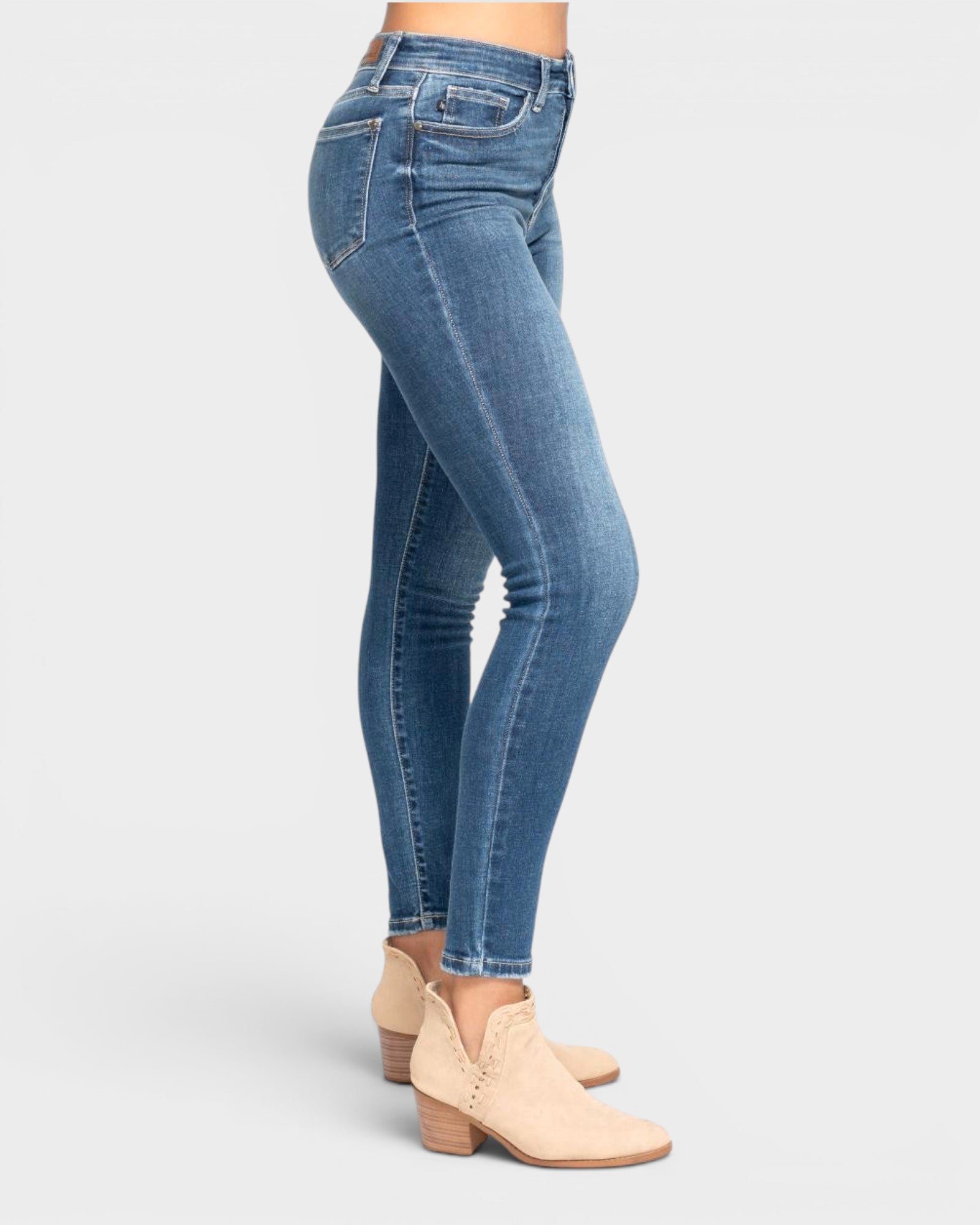 Blue jeans worn by a person on a white background