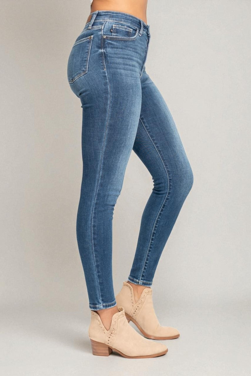 Blue jeans worn by a person on a plain background