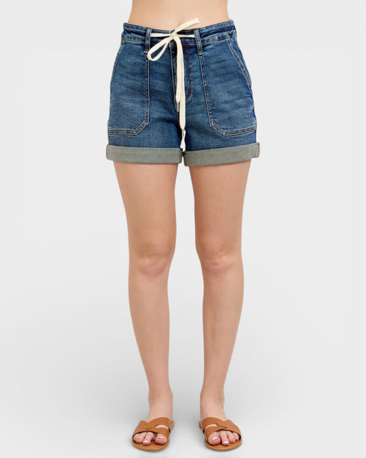 Denim shorts worn by a person on a white background