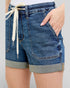 Blue denim shorts with a drawstring on a plain background