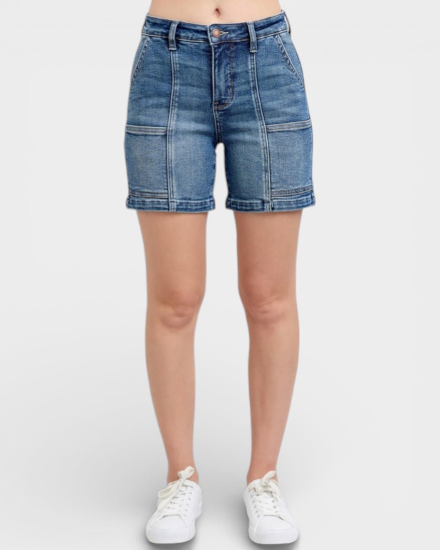 Blue denim shorts worn by a person on a white background