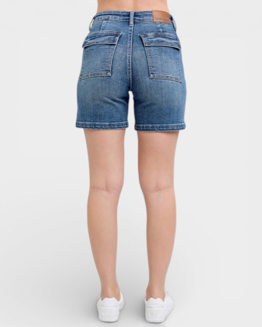 Blue denim shorts worn by a person on a white background