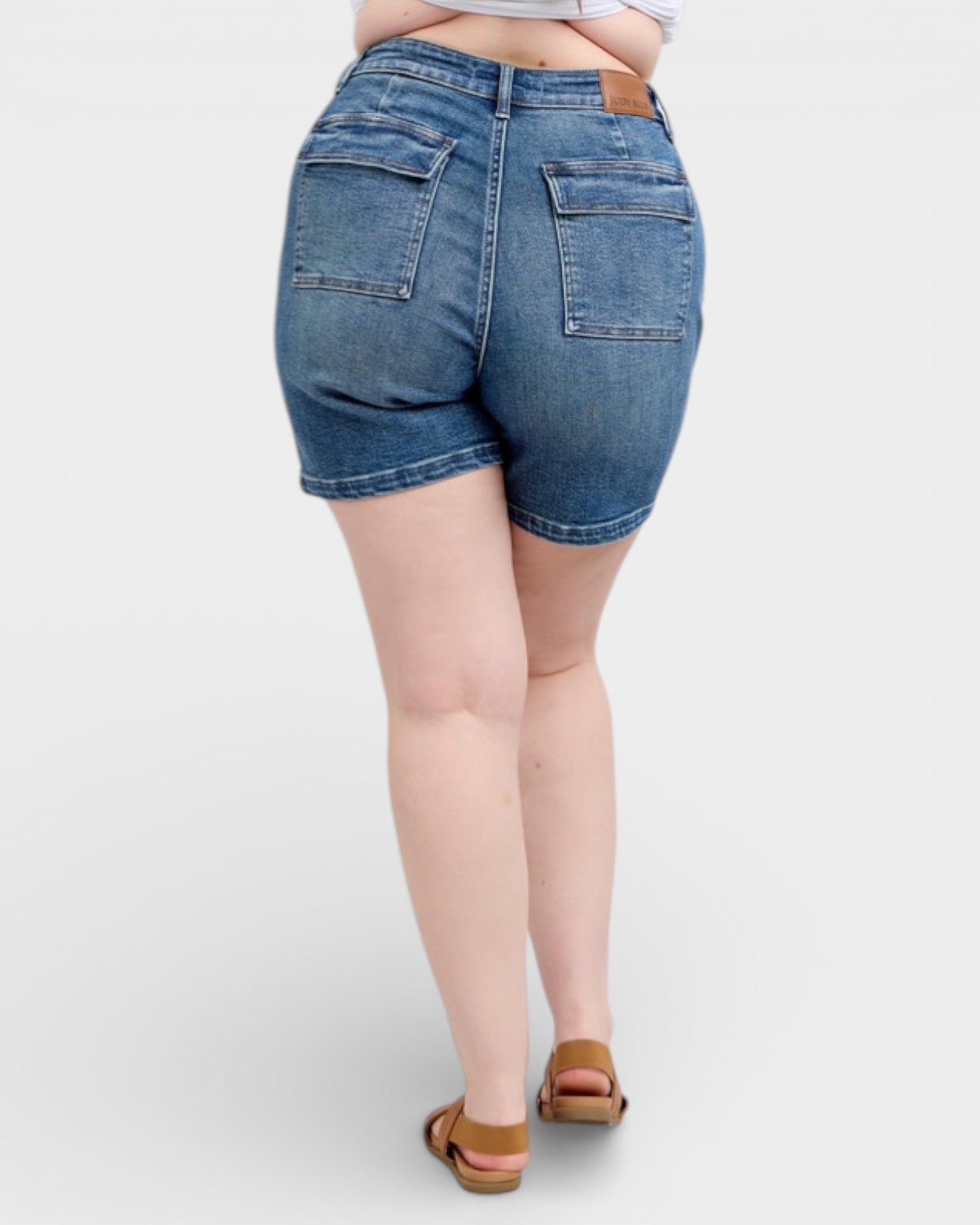 Person wearing blue denim shorts on a white background