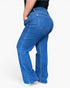 A person wearing blue denim jeans with a high waist and slight flare, shown from the back against a plain light background.