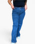 A person wearing medium-wash blue denim jeans with a black top and white socks, shown from the chest down against a plain light background.