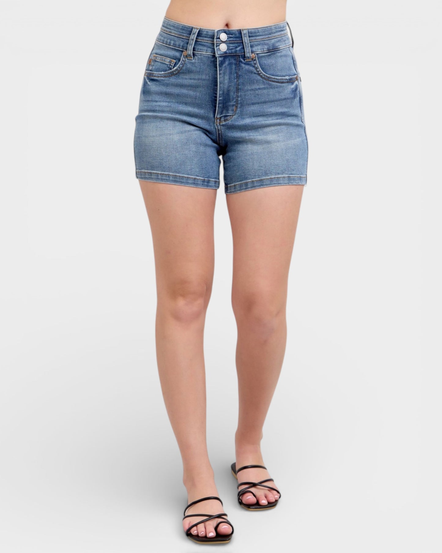 Denim shorts worn by a person on a white background