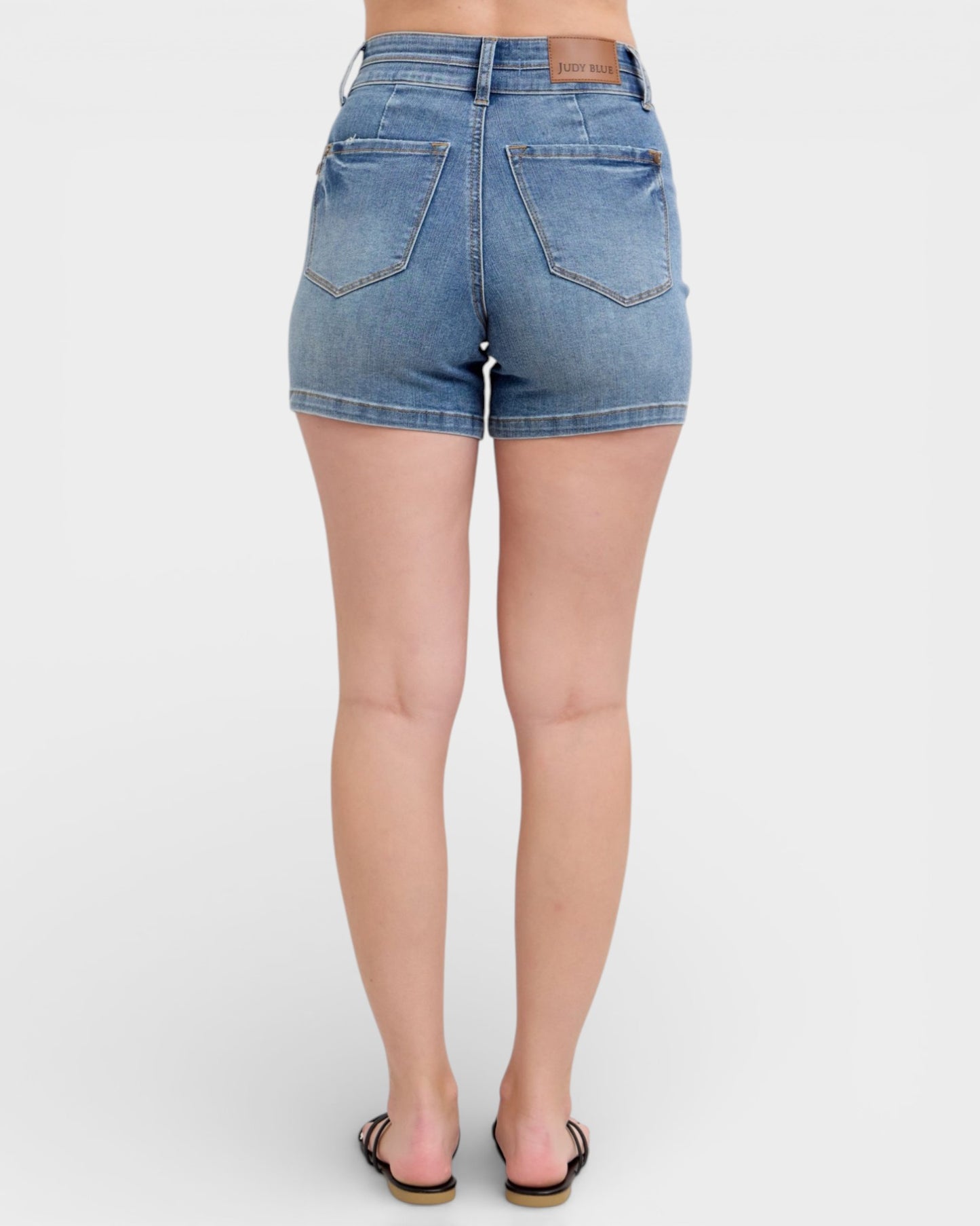 Denim shorts worn by a person on a white background