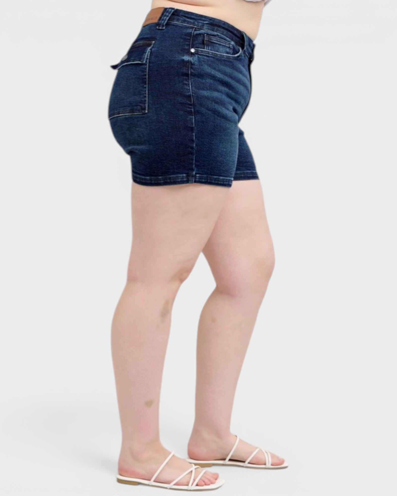 Person wearing dark blue denim shorts on a white background