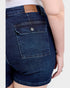 Close-up of blue denim shorts with a brand label on a white background