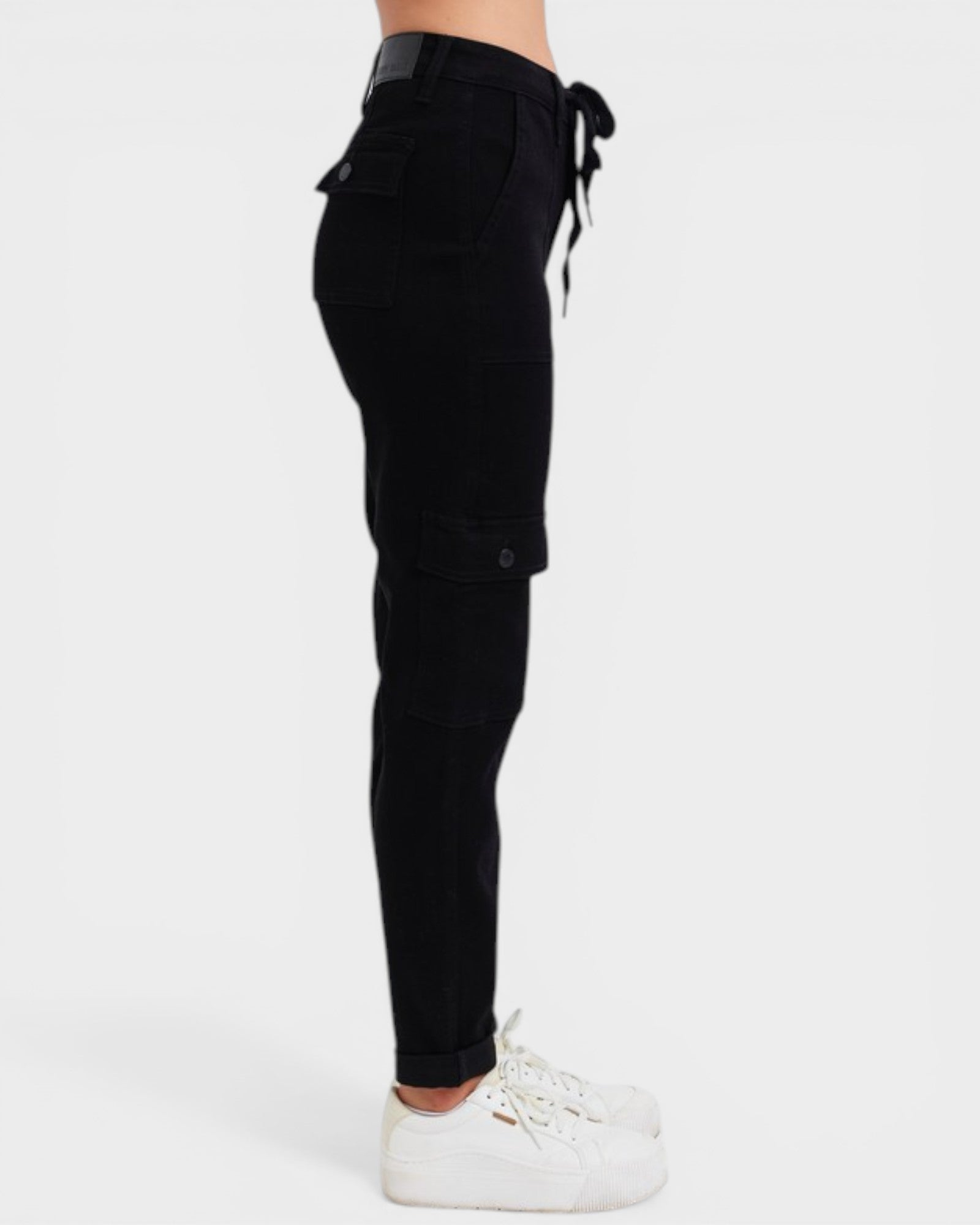 Black cargo pants worn by a person on a white background