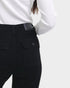Person wearing black pants with a white shirt on a light gray background