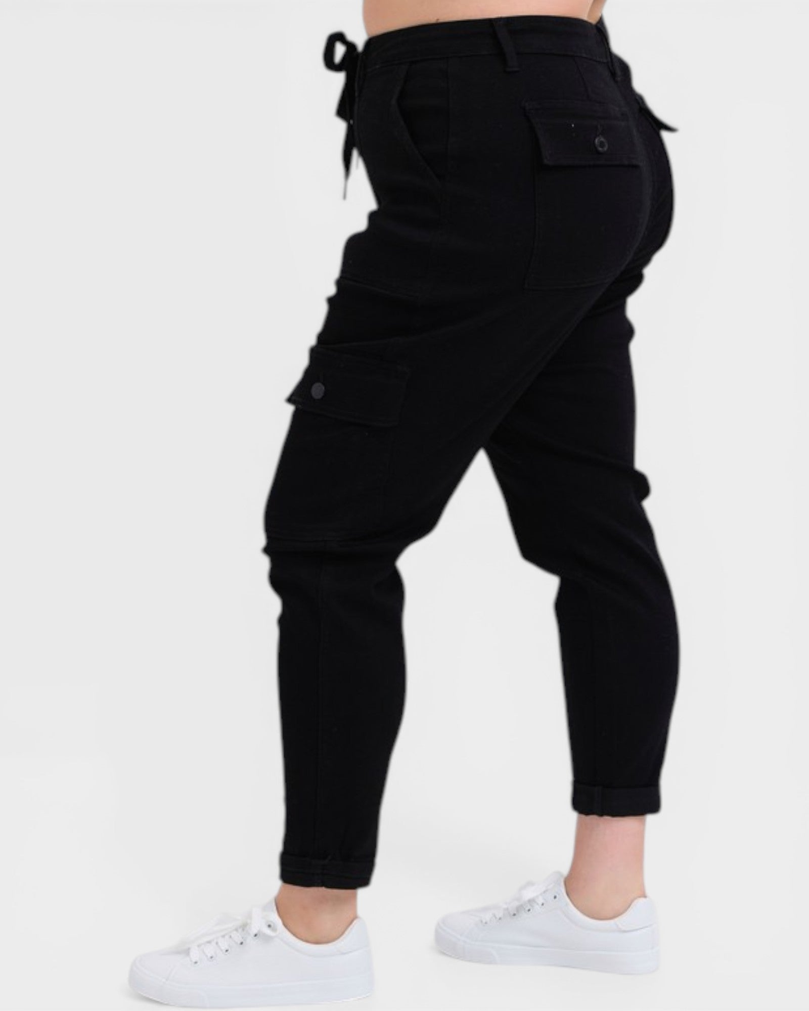 Black cargo pants worn by a person on a white background
