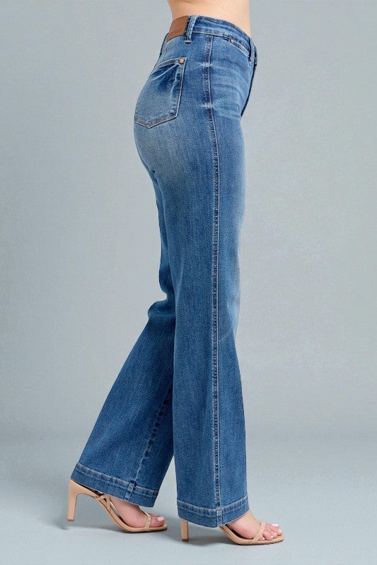 Blue jeans worn by a person on a gray background