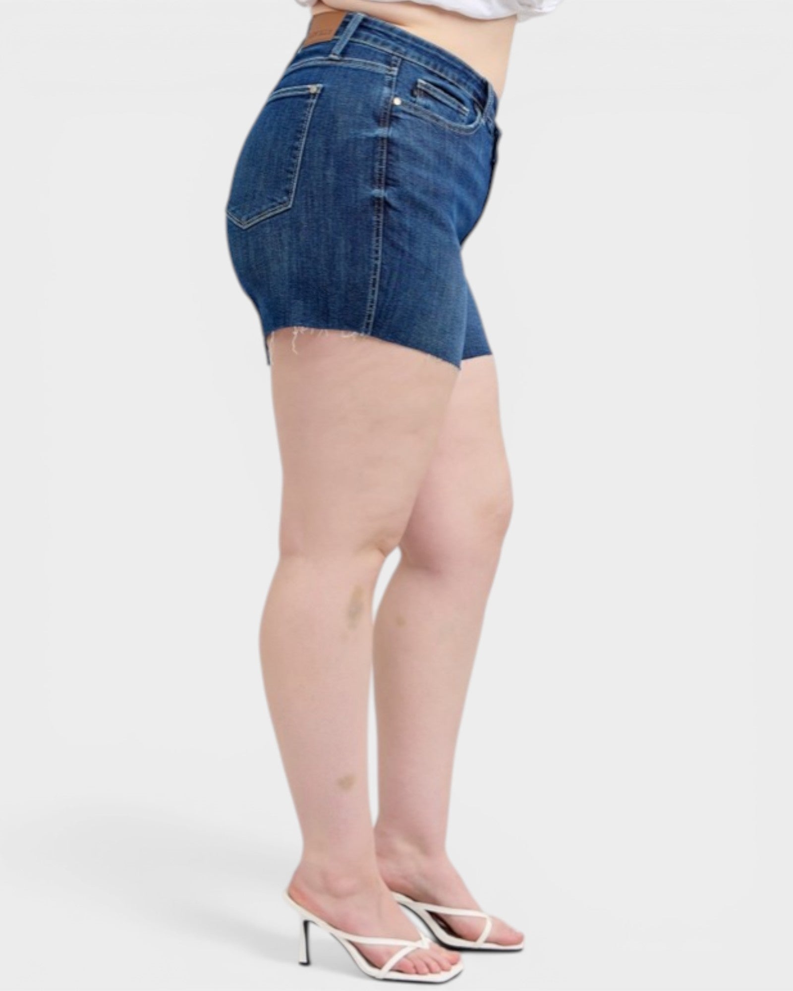 Person wearing blue denim shorts on a white background