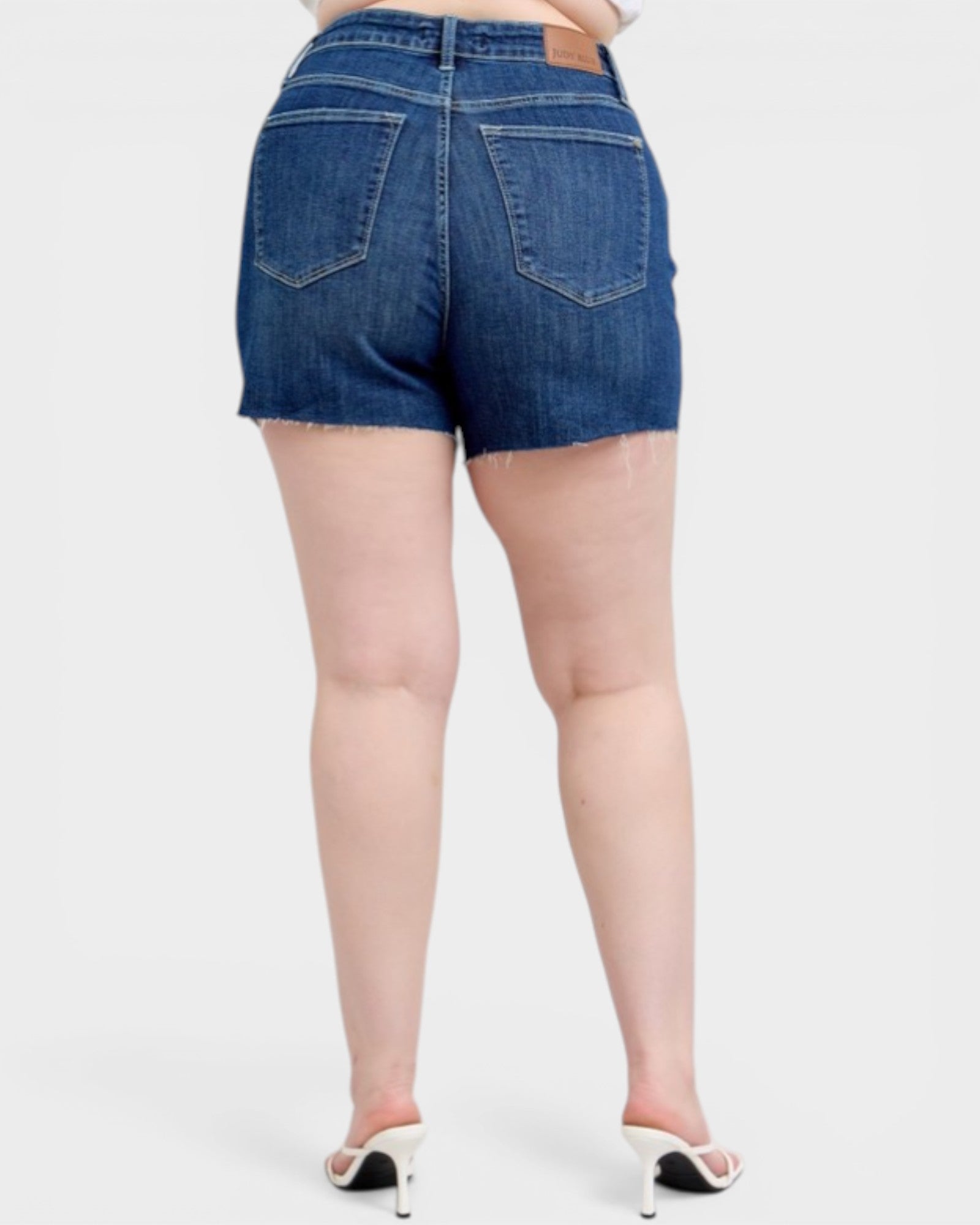 Denim shorts worn by a person on a white background