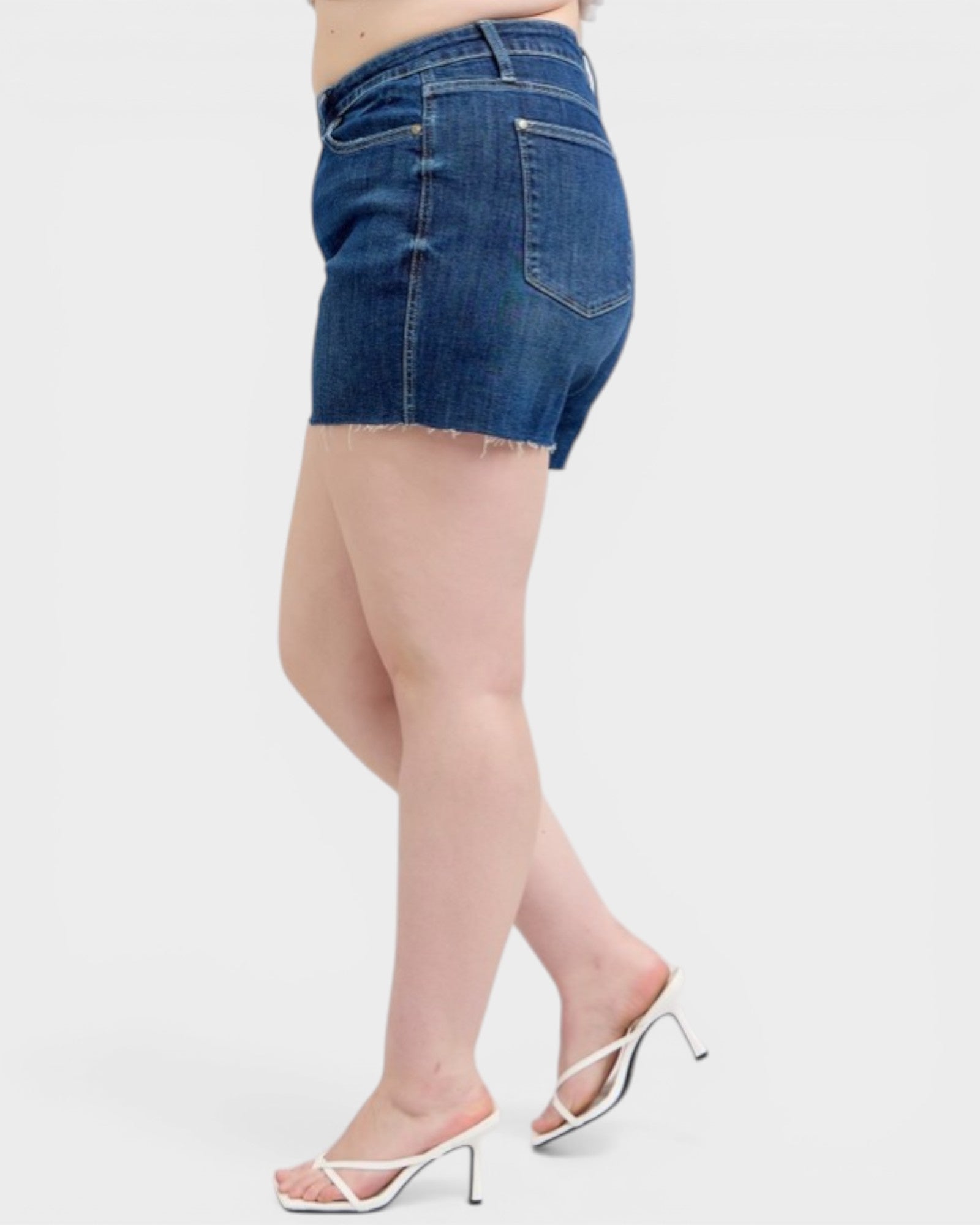Denim shorts worn by a person on a white background