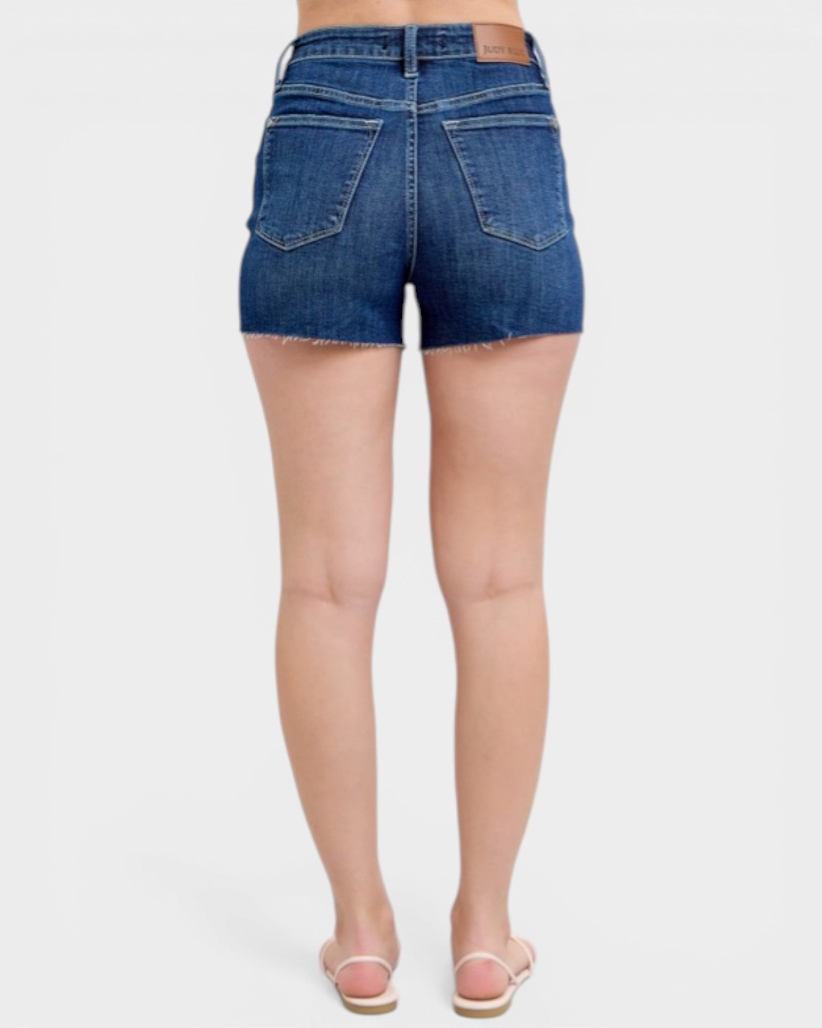 Blue denim shorts worn by a person on a white background
