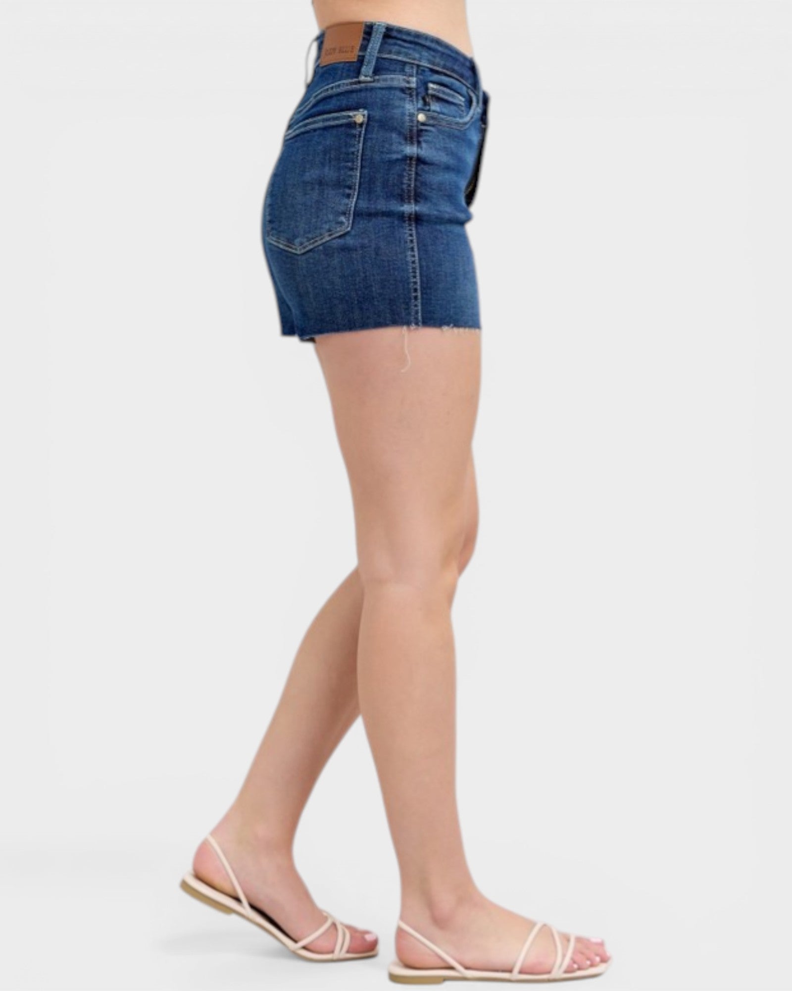 Denim shorts worn by a person on a white background
