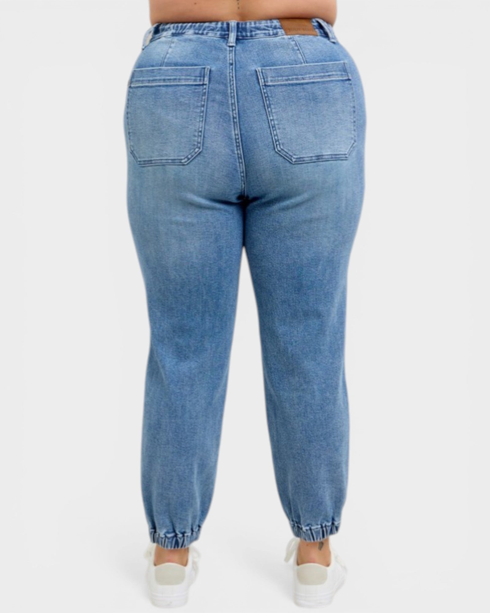 Blue jeans worn by a person on a white background