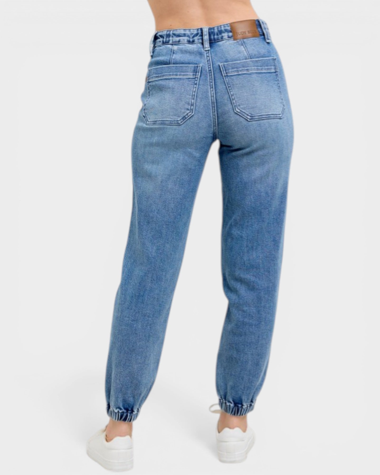 Blue jeans worn by a person on a white background