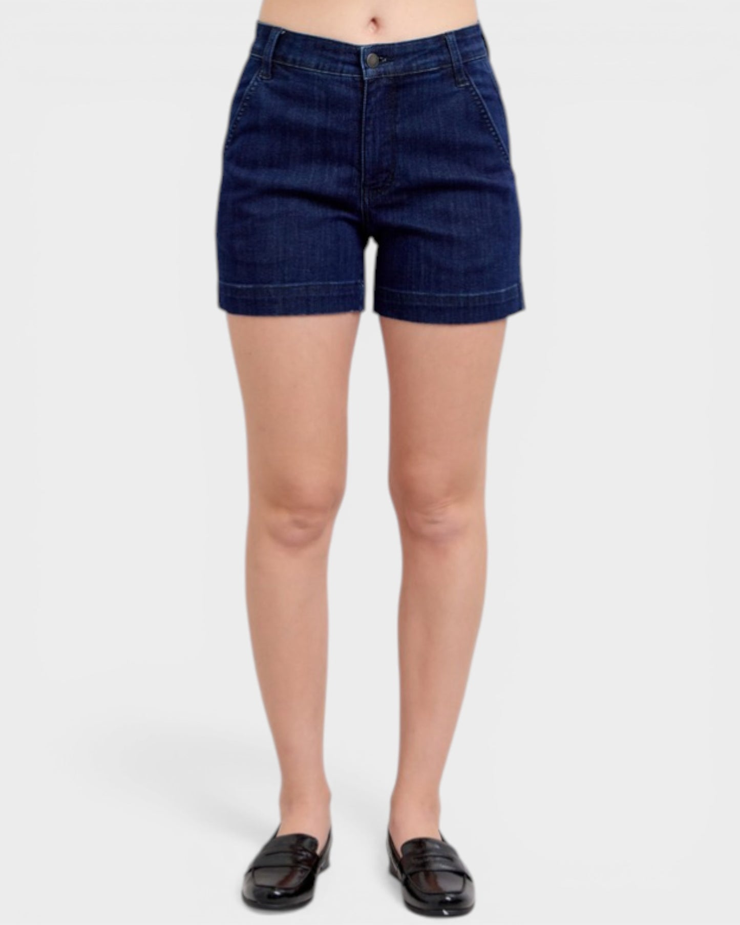 Person wearing dark blue denim shorts on a white background