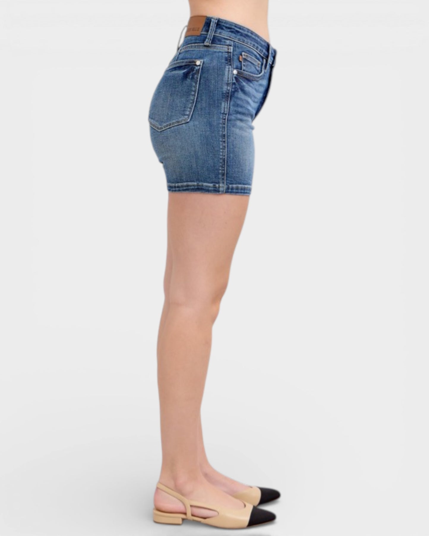 Denim shorts worn by a person on a white background