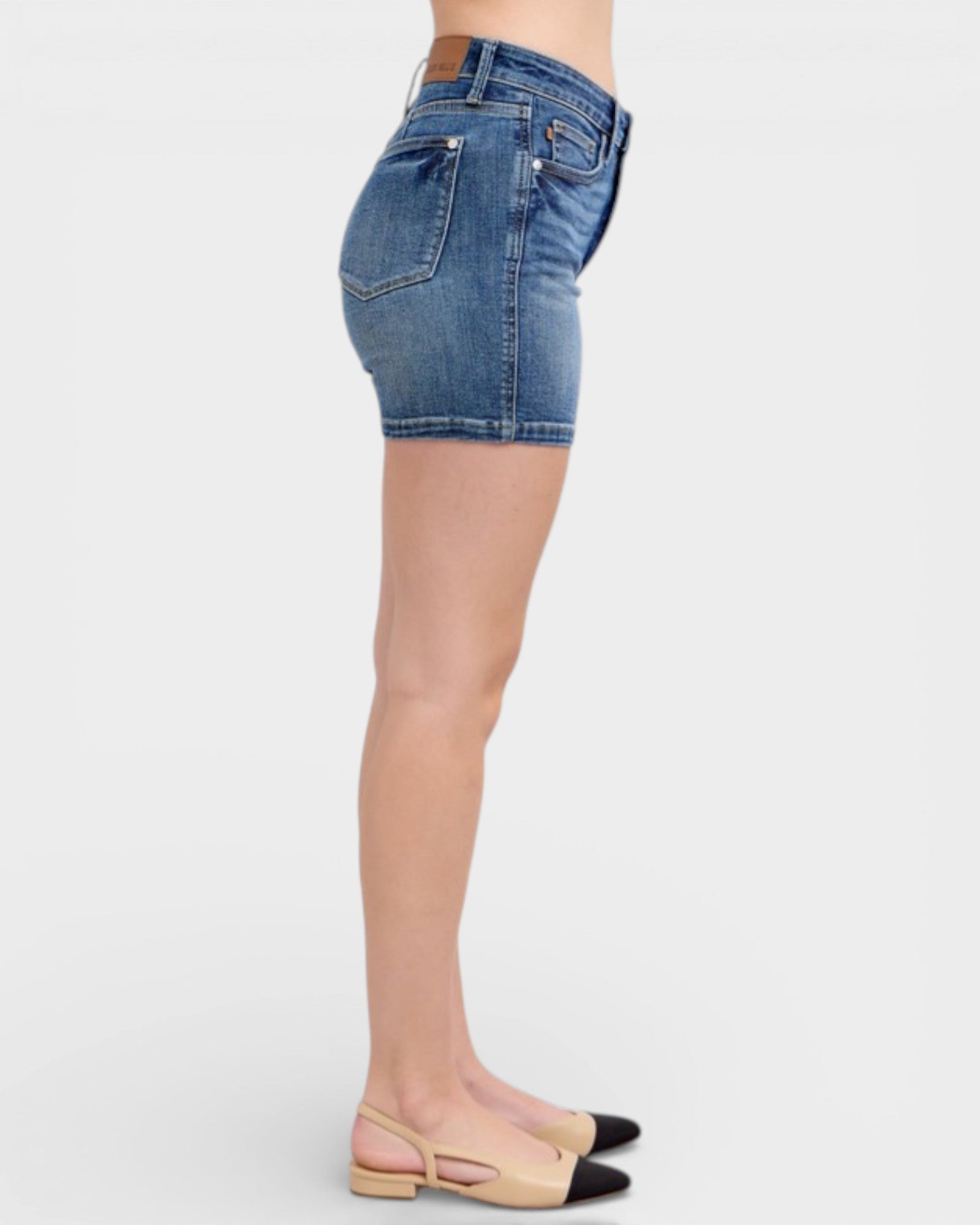 Denim shorts worn by a person on a white background