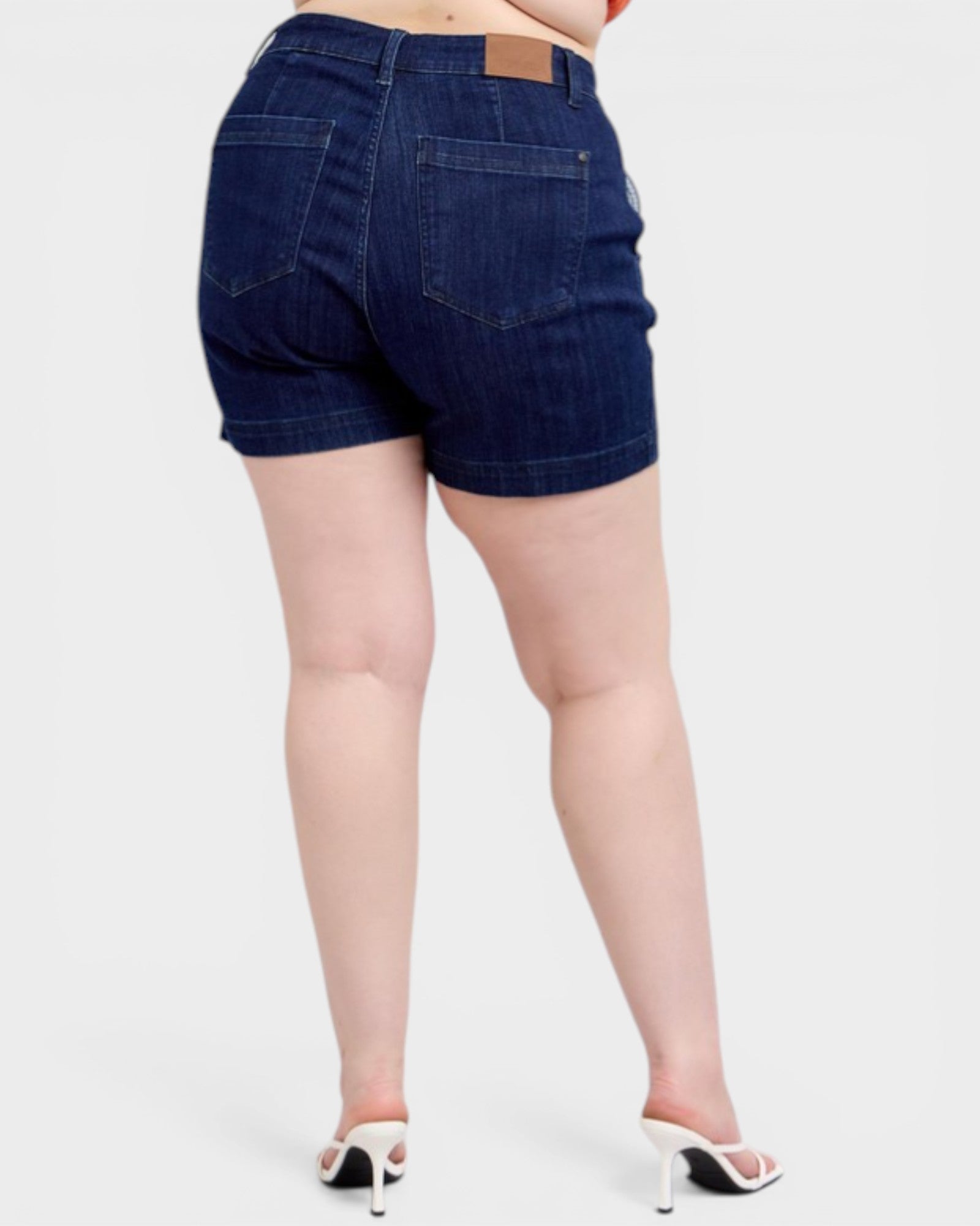 Denim shorts worn by a person on a white background