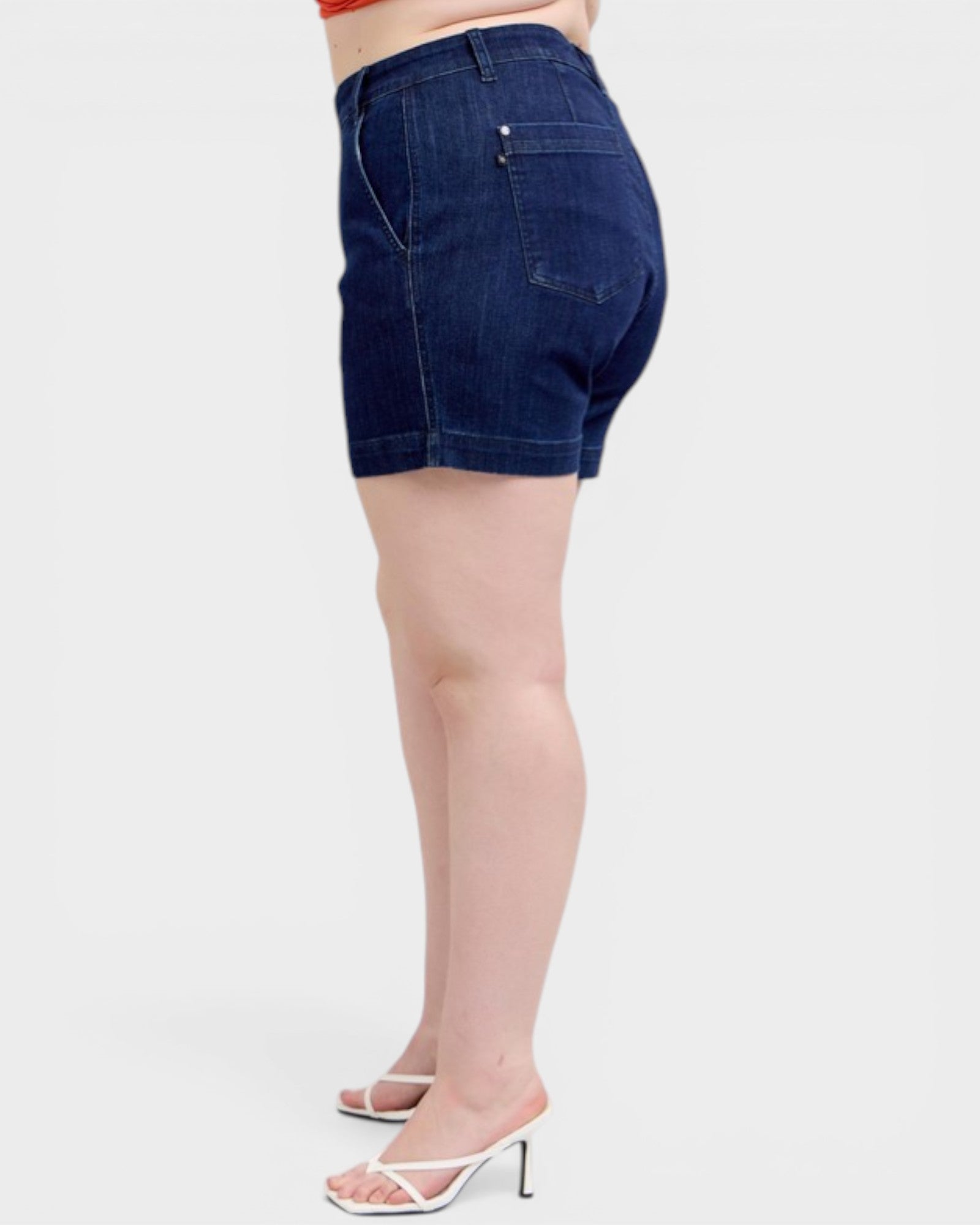 Denim shorts worn by a person on a white background