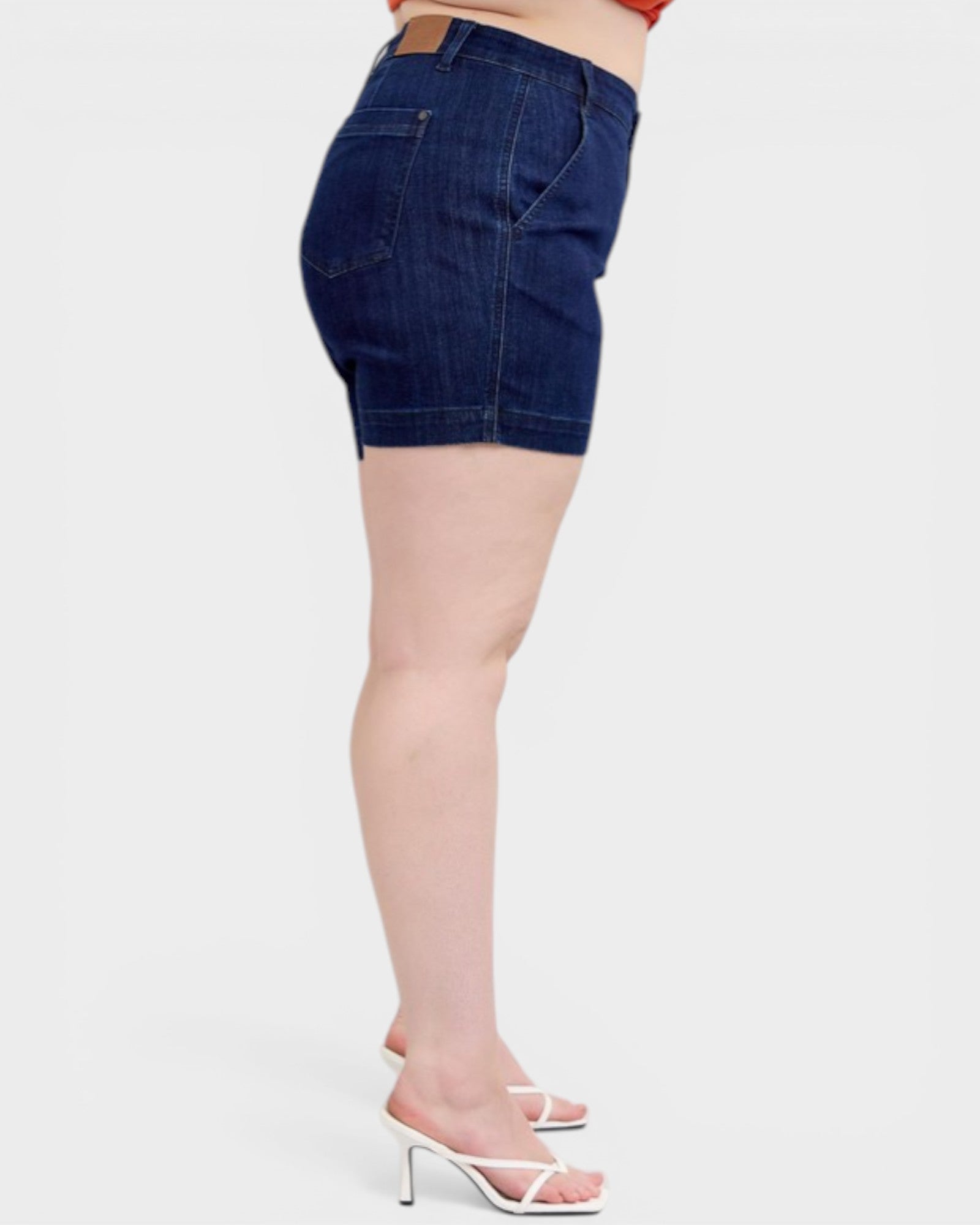 Denim shorts worn by a person on a white background
