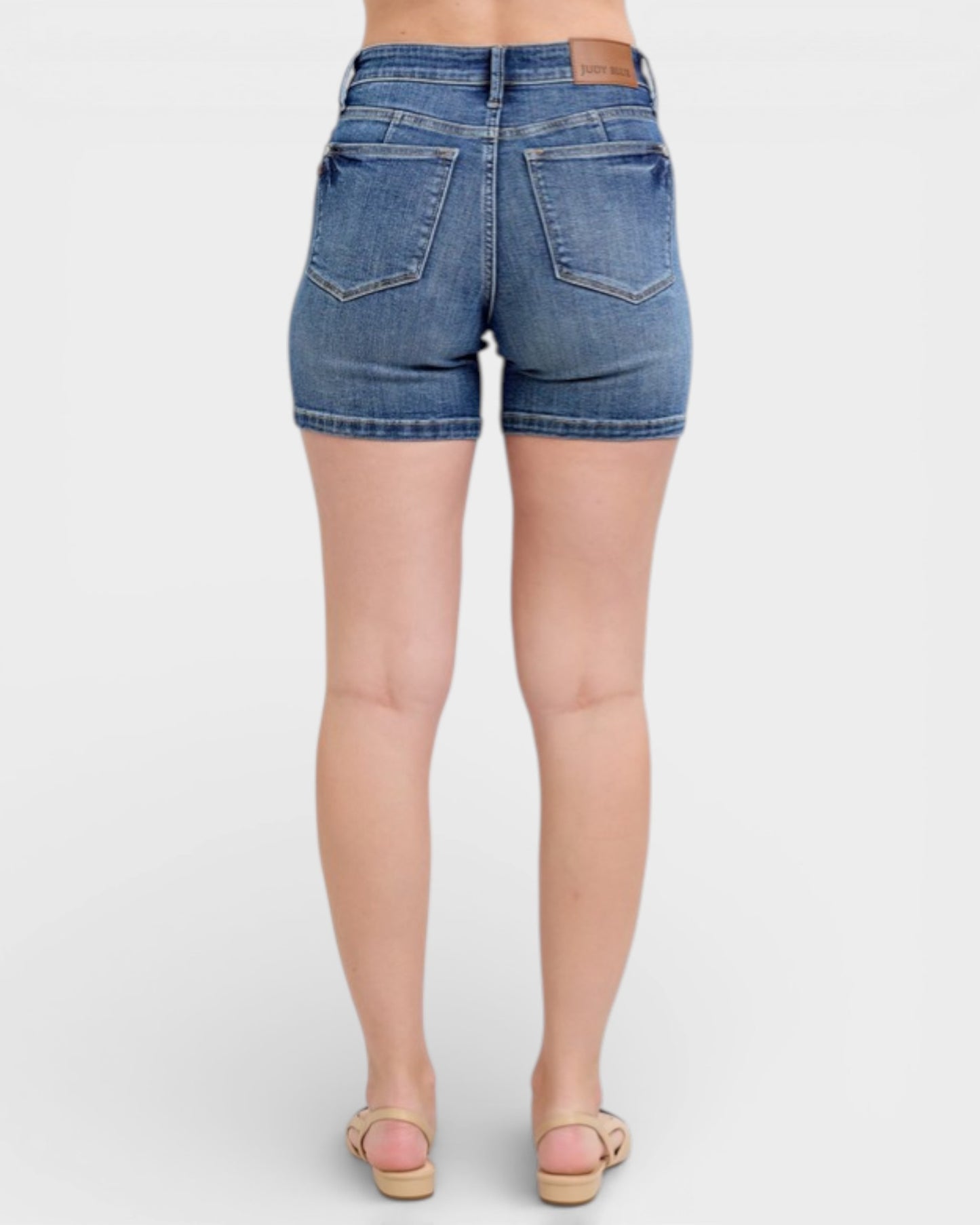 Denim shorts worn by a person on a white background
