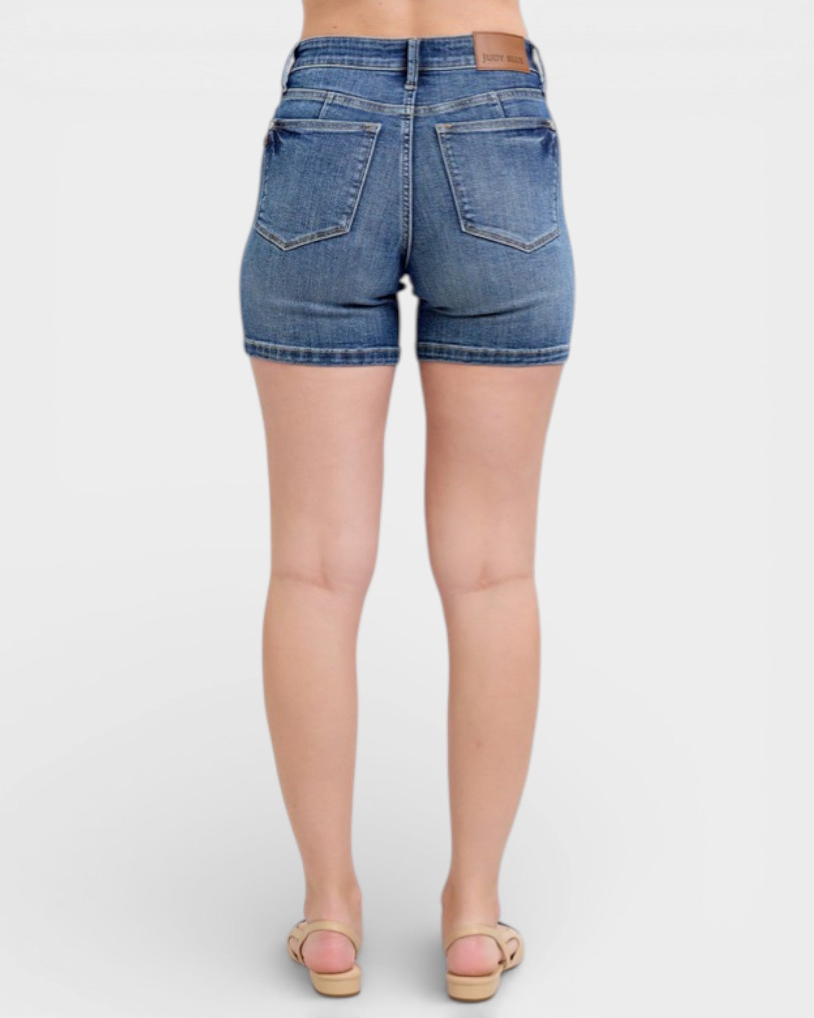 Denim shorts worn by a person on a white background