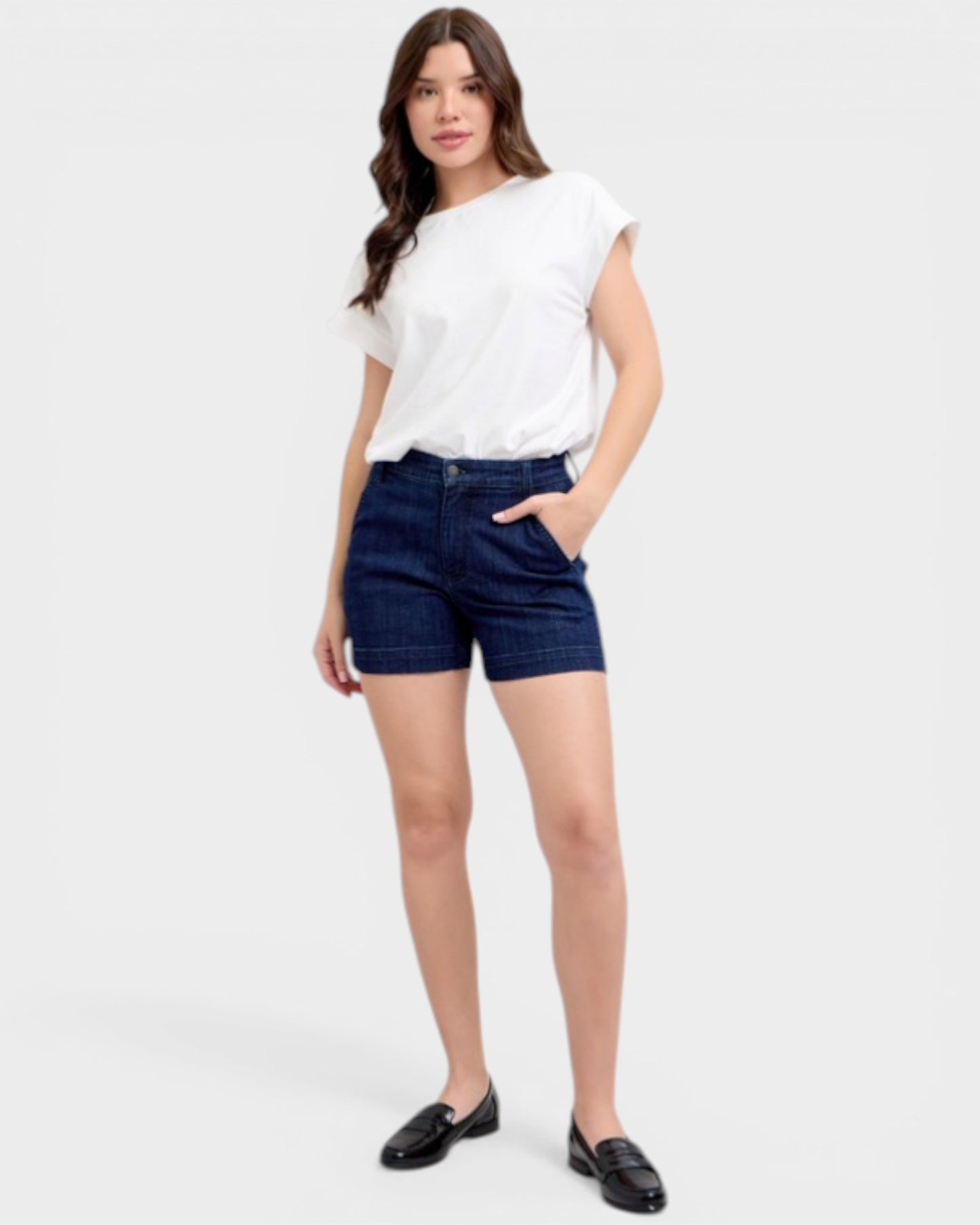 Woman wearing a white t-shirt and dark denim shorts on a white background