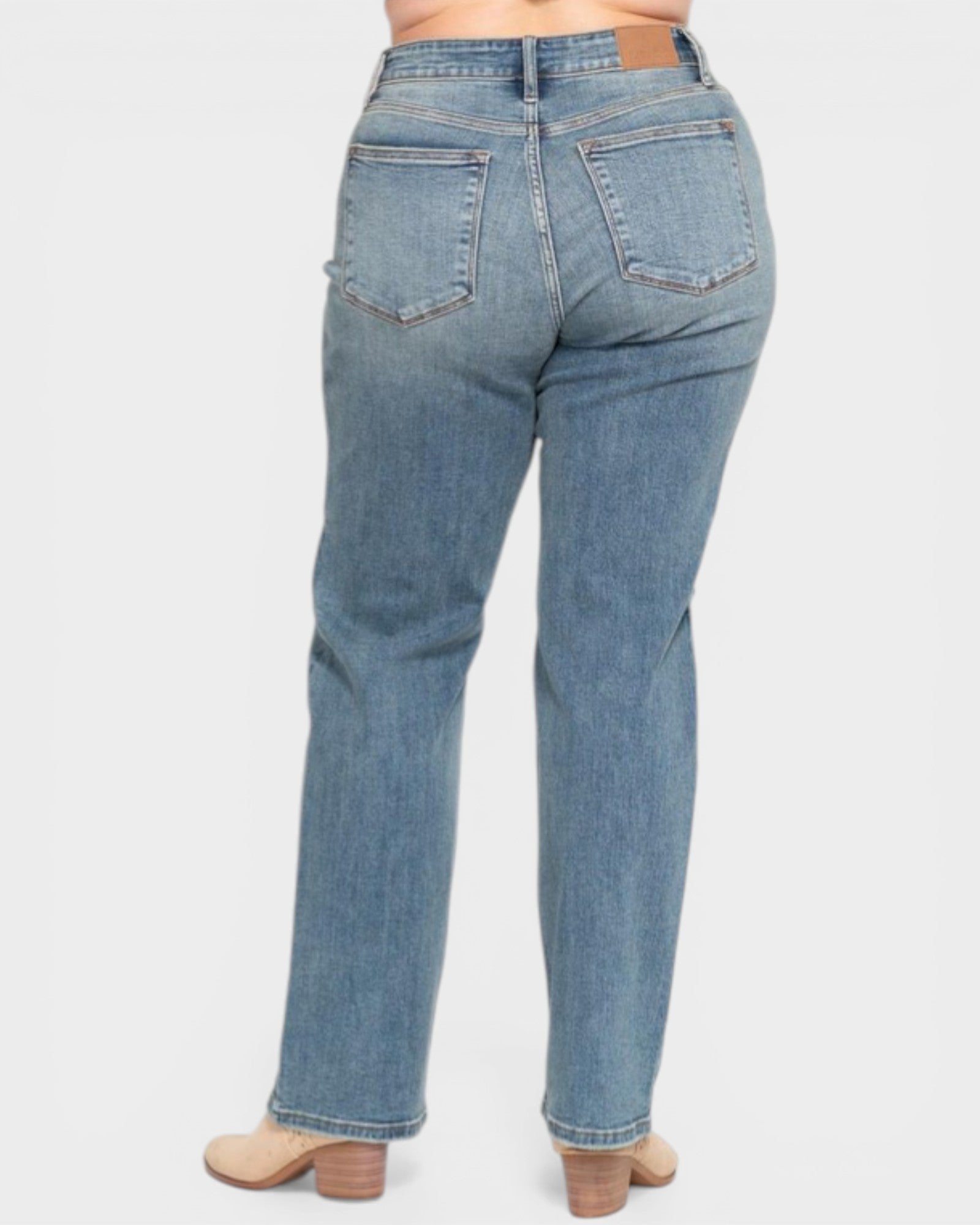 Blue jeans worn by a person on a white background